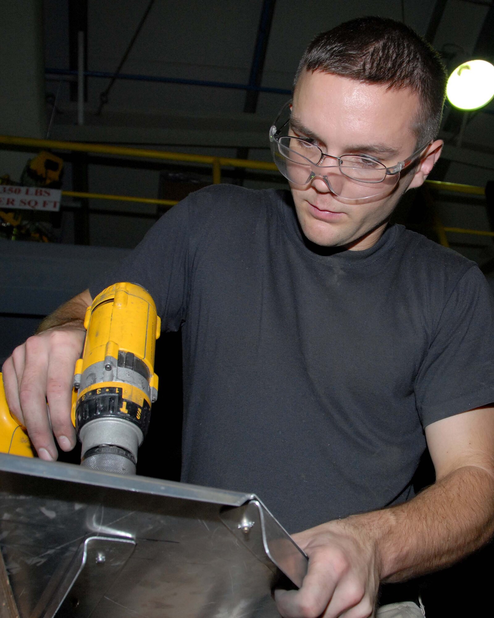 SOUTHWEST ASIA -- Senior Airman Jacob Taylor drills holes to house rivets for shelving in the fabrication shop here Oct. 7. Airman Taylor is an aircraft structural maintenance journeyman with the 380th Expeditionary Aircraft Maintenance Squadron. Airman Taylor is deployed from Beale Air Force Base, Calif. (U.S. Air Force photo by Tech. Sgt. Denise Johnson) (released)