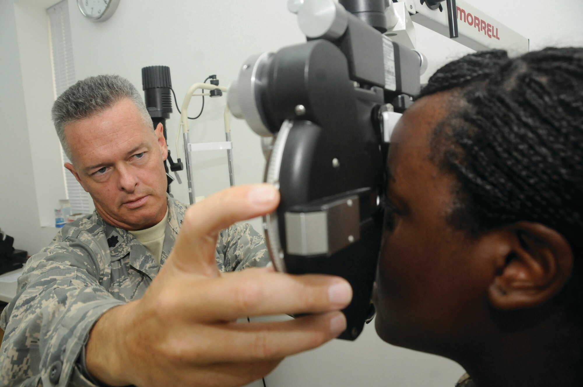 Colonel Collins changes the trial lenses on a phoropter to determine the eye glass and contact prescriptions for Airman Simmons here Oct. 14. The optometry clinic is the first of its kind in Southwest Asia and provides eye care for more than 8,000 U.S. servicemembers deployed here. (U.S. Air Force photo by Staff Sgt. Darnell T. Cannady)