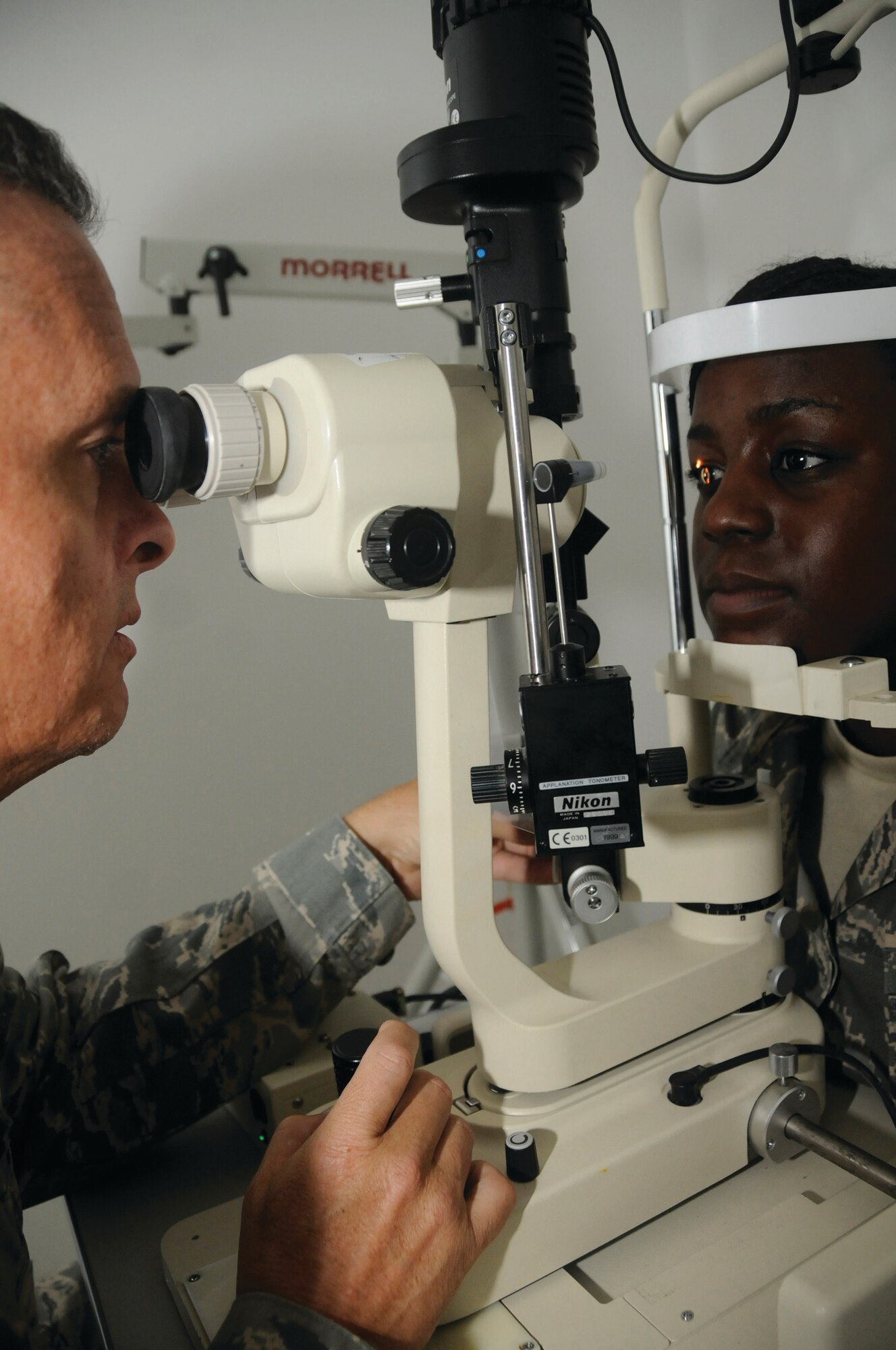 Colonel Collins uses a biomicroscope to magnify the surface of the eye allowing him to examine the front half of Airman Simmons’ eye here Tuesday. The optometry clinic maintains servicemembers’ vision standards, which are essential for operational readiness. (U.S. Air Force photo by Staff Sgt. Darnell T. Cannady)