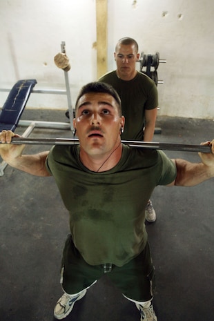 Cpl. Arron M. Stephens (front), 27,  a former personal trainer, teaches Cpl. Chad R. Hochstatter, 23,  proper form as he pushes out a set of squats in the weight room at Camp Hit, Iraq, Oct. 19.  Both Marines are administrative clerks with Headquarters and Service Company, Task Force 3rd Battalion, 7th Marine Regiment, Regimental Combat Team 5.  Stephens has been using the knowledge he gained to become a certified personal trainer to help Marines get themselves in shape during the battalion's deployment to Iraq.::r::::n::