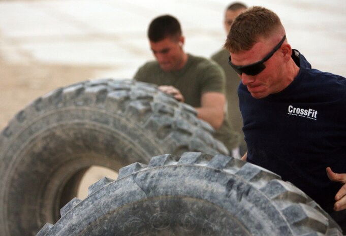 1st Lt. Patrick C. Holland, 24, a platoon commander with Combined Anti-Armor Team Blue, Task Force 3rd Battalion, 7th Marine Regiment, Regimental Combat Team 5, from Waco, Texas, flips a truck during a CrossFit competition at Camp Hit, Iraq, Oct. 24. During each event, the Marines pushed themselves and each other to the limit with every exercise so they could defeat the opposing team.::r::::n::