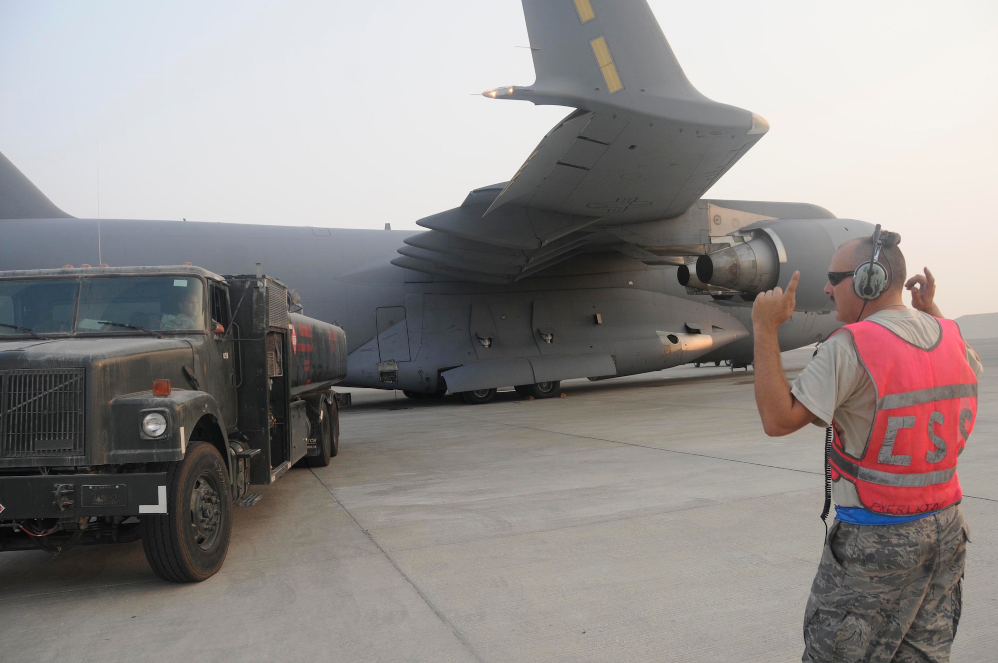 Staff Sgt. Brian Carroll, hydraulics specialist assigned to the 8th Expeditionary Air Mobility Squadron, directs a fuel truck after it finished refueling a C-17 Globemaster III Oct. 17, 2008, at an undisclosed air base in Southwest Asia.  Sergeant Carroll, a native of New Martinsville, W.Va., is deployed from Charleston Air Force Base, S.C., in support of Operations Iraqi and Enduring Freedom and Joint Task Force-Horn of Africa. (U.S. Air Force photo by Staff Sgt. Darnell T. Cannady/Released)
