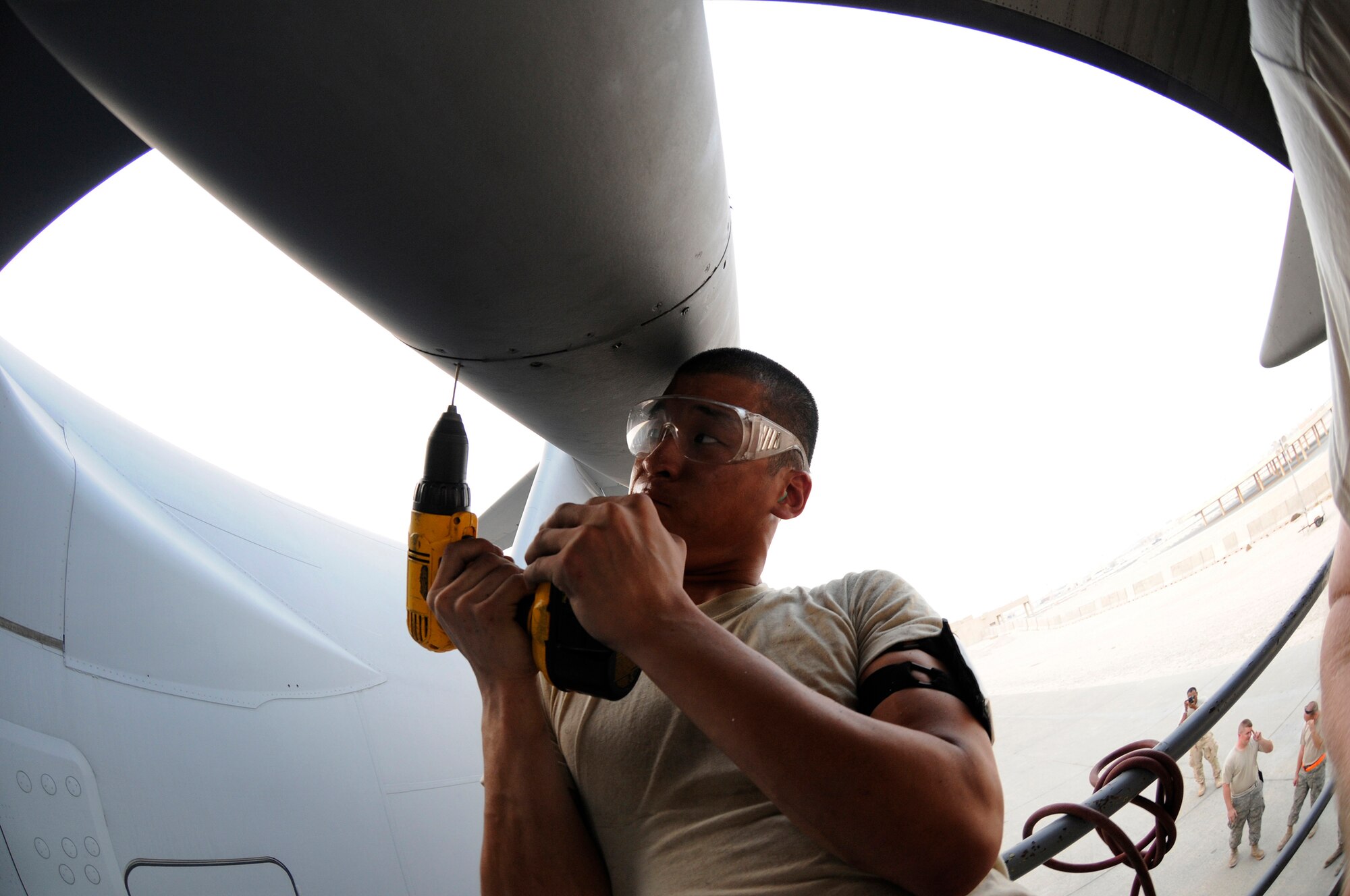 Airman 1st Class Matthew Enter, 379th Expeditionary Maintenance Squadron, puts a little muscle into drilling out a stripped screw head, October 17, 2008, at an undisclosed air base in Southwest Asia.  The bad screws are being removed so the crew chiefs can pull the panel and do maintenance on a C-17 Globemaster III.  Airman Enter, a native of Rochester, N.Y., is deployed from Fairchild Air Force Base, Wash., in support of Operations Iraqi and Enduring Freedom and Joint Task Force-Horn of Africa.  (U.S. Air Force photo by Tech. Sgt. Michael Boquette/Released)