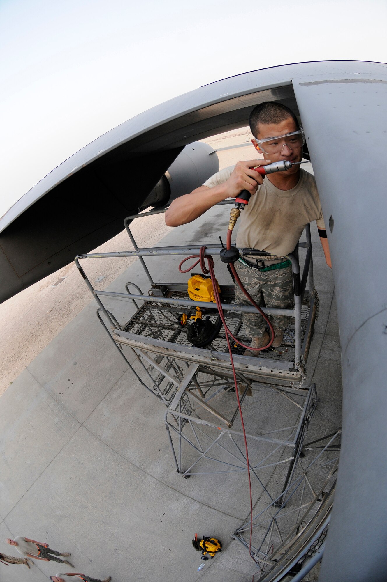 Airman 1st Class Matthew Enter, 379th Expeditionary Maintenance Squadron, works high on a maintenance stand drilling out a stripped screw head, October 17, 2008, at an undisclosed air base in Southwest Asia.  The bad screws are being removed so the crew chiefs can pull the panel and do maintenance on a C-17 Globemaster III.  Airman Enter, a native of Rochester, N.Y., is deployed from Fairchild Air Force Base, Wash., in support of Operations Iraqi and Enduring Freedom and Joint Task Force-Horn of Africa.  (U.S. Air Force photo by Tech. Sgt. Michael Boquette/Released)