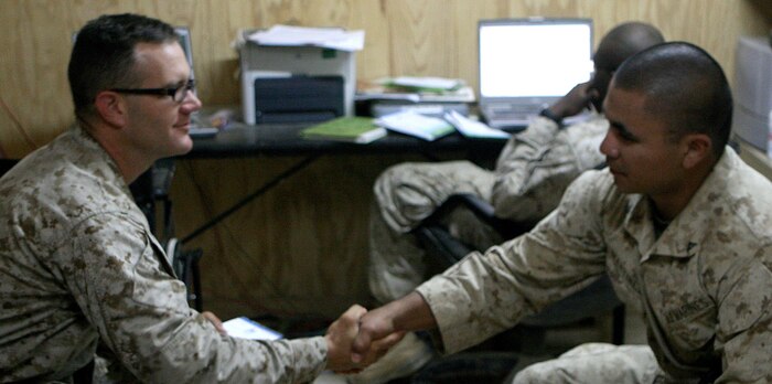 Navy Lt. Malcolm Brown, the Battalion surgeon with Task Force 2nd Battalion, 2nd Marine Regiment, Regimental Combat Team 5, completes a Post Deployment Health Assessment (PDHA) interview with Lance Cpl. Antonio Martinez a machine gunner with Weapons Company, 2nd Bn., 2nd Marines, at Rawah, Iraq, Oct. 18. More than 900 service members with the battalion will complete PDHAs before returning home.::r::::n::
