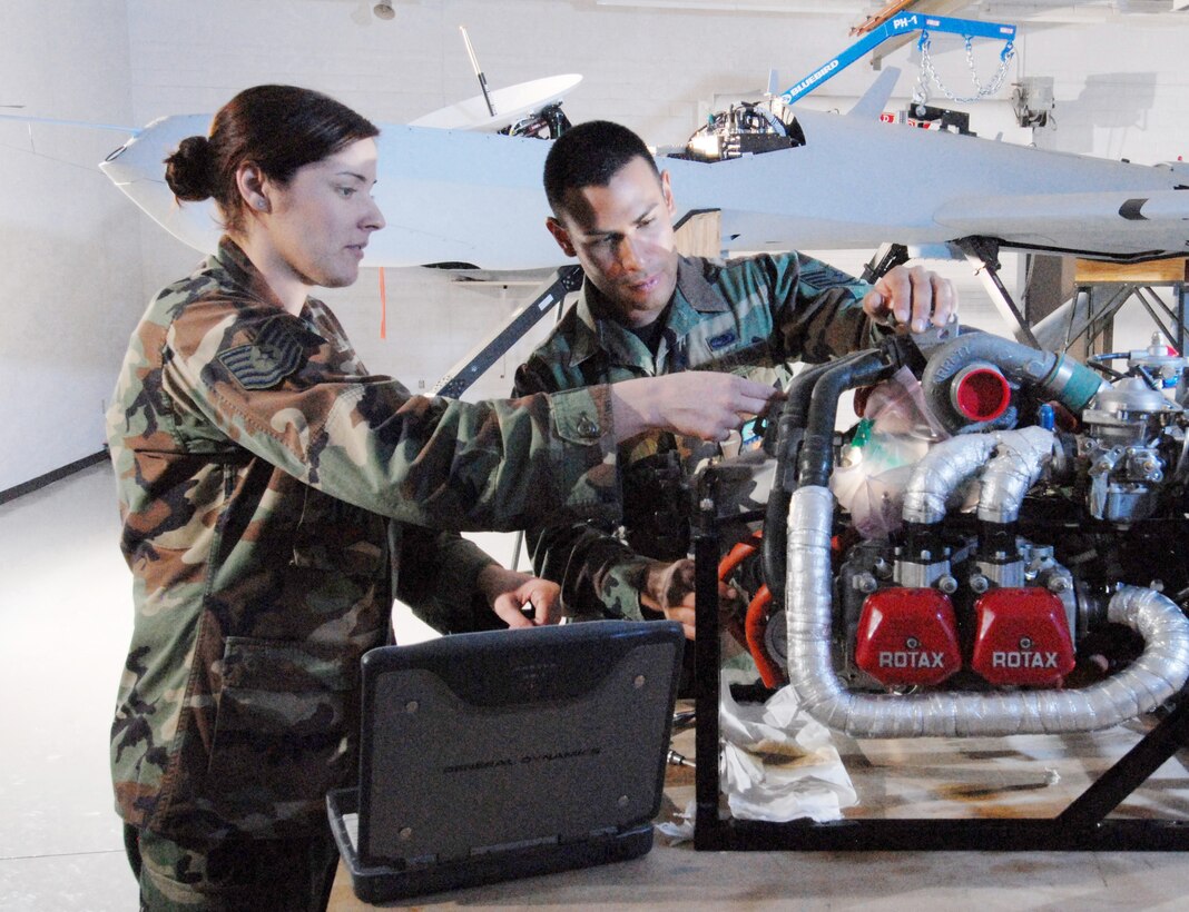 Technical Sgt. Rebecca Hatfield, left, an instructor assigned to the Field Training Detachment, 163rd Maintenance Group, discusses oil pump installation on the engine of an MQ-1 Predator unmanned aerial vehicle with Staff Sgt. Carlos Barrera, a crew chief assigned with the 163rd Refueling Wing at March ARB., Oct. 15. Members of the FTD train active duty, Reserve and Air National Guard personnel on Predator maintenance operations. (U.S. Air Force photo by Senior Airman Matt Smith)