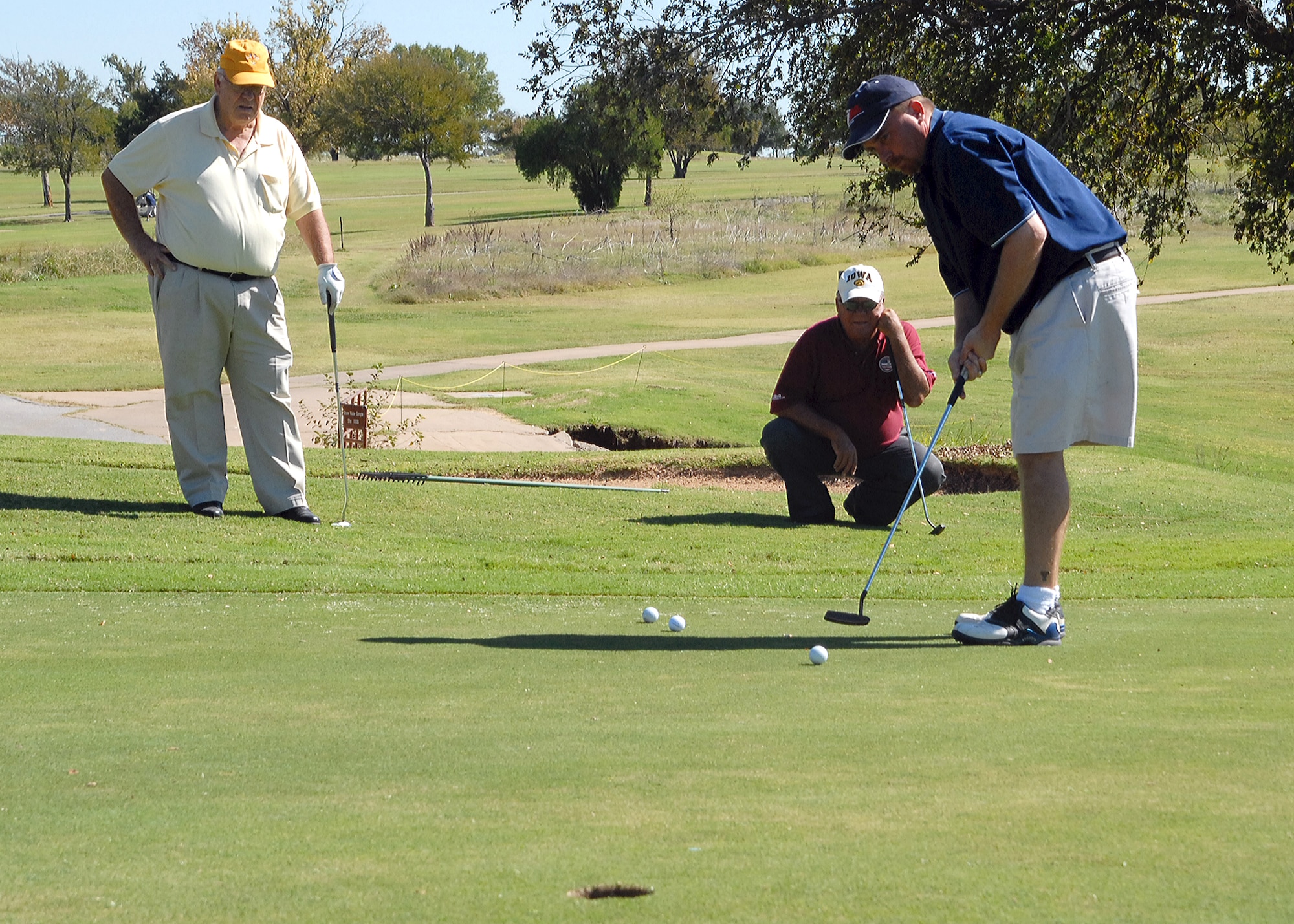 Scott Lewis, a tournament participant, putts as his father Wayne Lewis and friend Jodi Walker look on at the Wind Creek Golf Course 50th Anniversary Tournament Oct. 17. Thirty-eight teams participated in the four man scramble. (U.S. Air Force photo/Lou Anne Sledge)