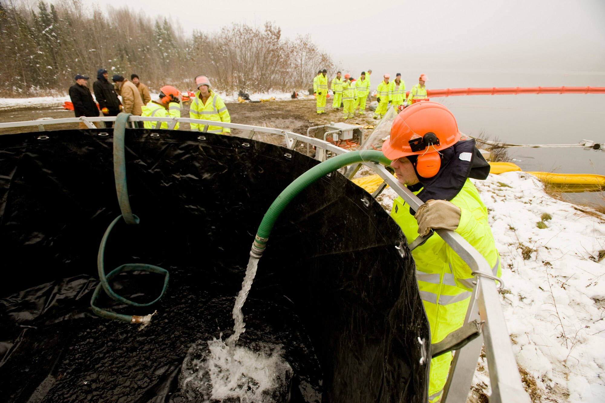 ELMENDORF AIR FORCE BASE, Alaska -- Steve Brunk, 611th Civil Engineer Squadron, pours the simulated oil in to a tank at Sixmile Lake Oct. 16. From the tank, the oil will be transported to a truck and removed of the site. (U.S. Air Force photo/Senior Airman Jonathan Steffen)