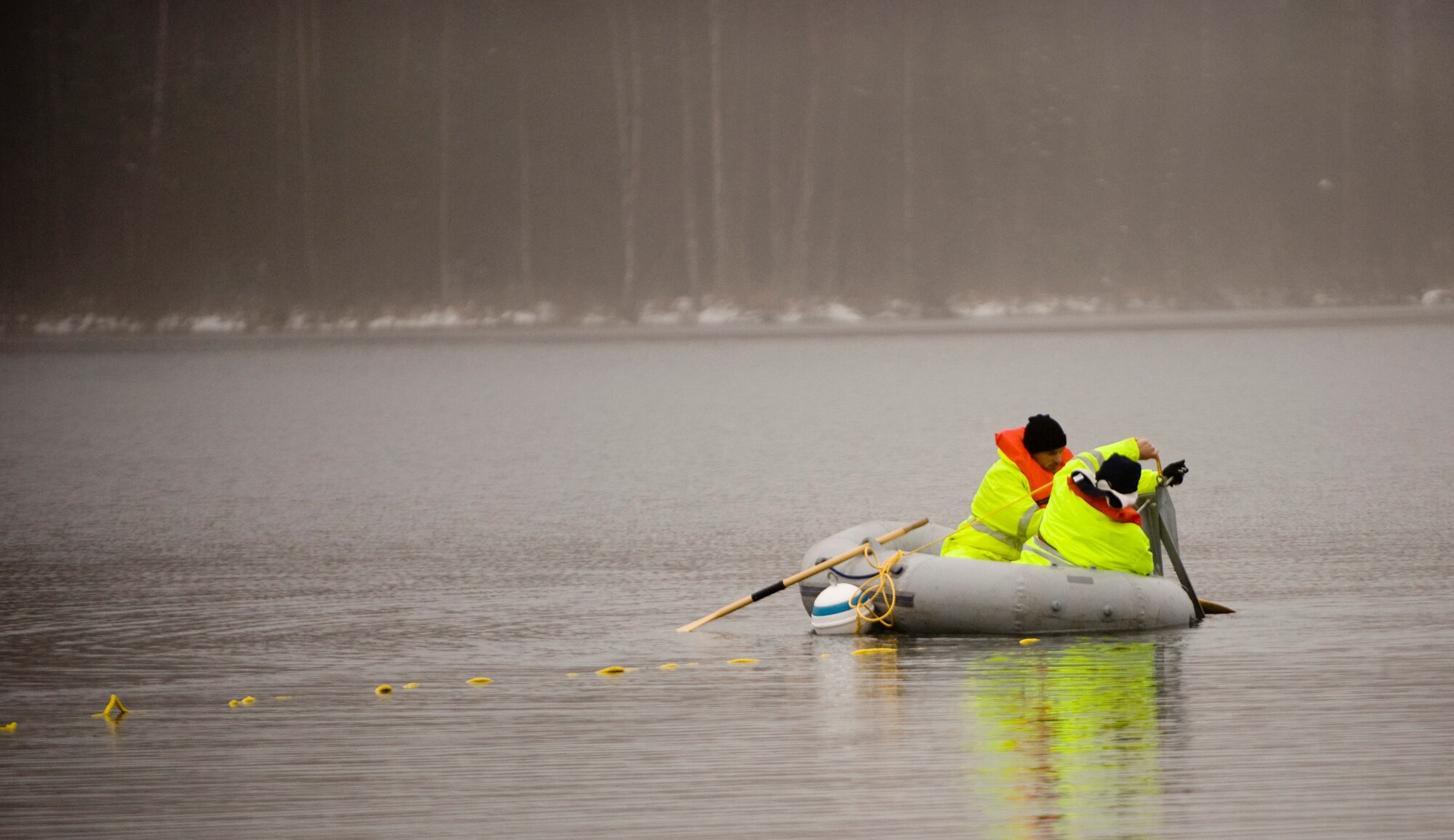 ELMENDORF AIR FORCE BASE, Alaska -- Master Sgt. William Haley and Tech. Sgt. Jeff Jones, 611th Civil Engineer Squadron, drops an anchor to secure a boom at Sixmile Lake Oct. 16. The boom is use to contain oil during an aquatic spill. (U.S. Air Force photo/Senior Airman Jonathan Steffen)