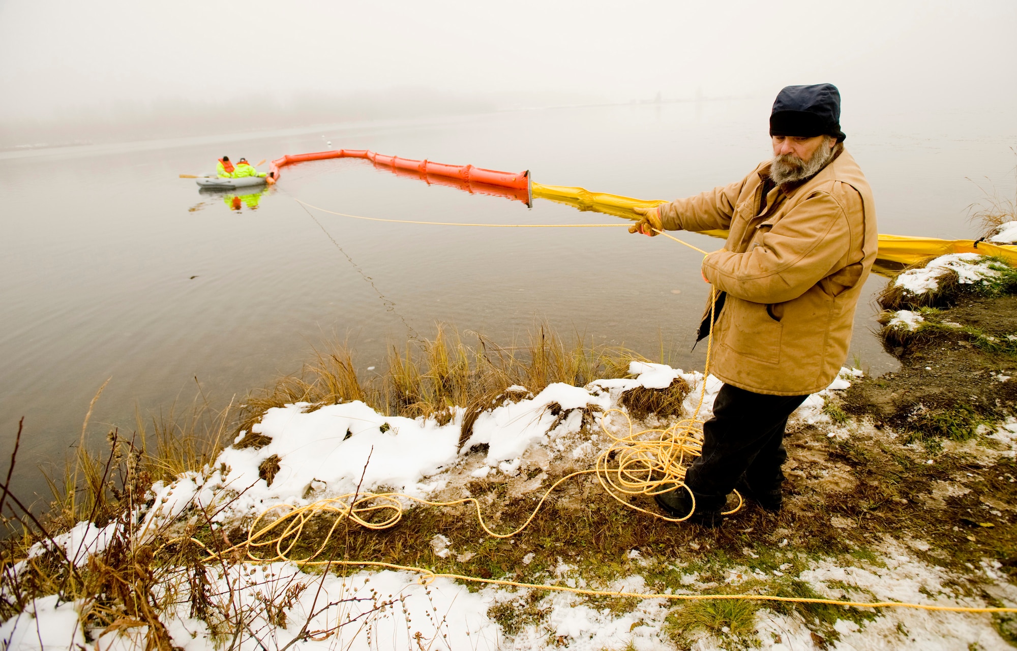 ELMENDORF AIR FORCE BASE, Alaska -- Dennis Bowie, Navy Supervisor of Salvage, pulls in the boom at Sixmile Lake Oct. 16. The boom is use to contain oil during an aquatic spill. (U.S. Air Force photo/Senior Airman Jonathan Steffen)