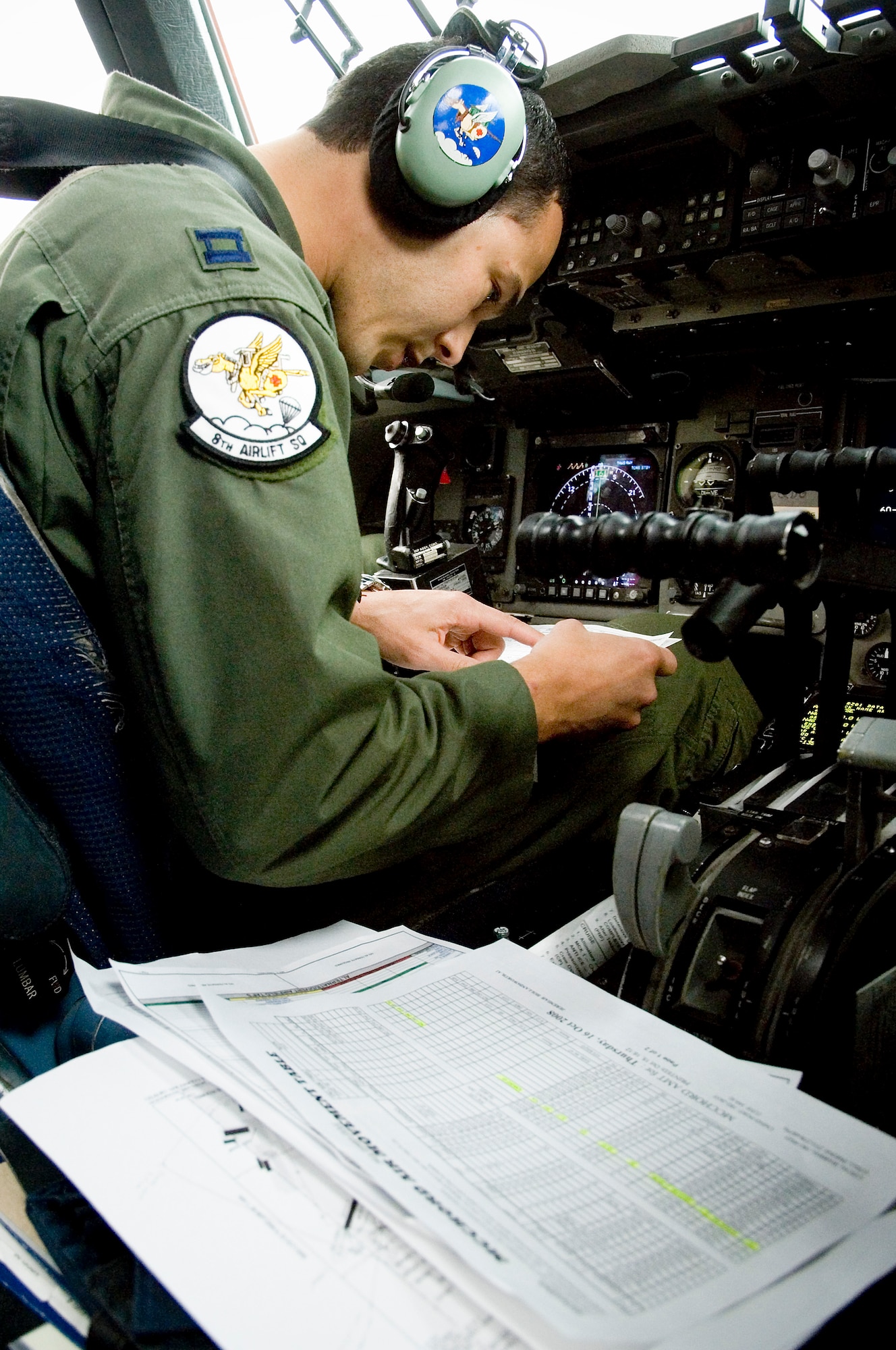Capt. Javier Orama, 8th Airlift Squadron, pilot, reviews pre-flight checklists prior to departure on a local training flight Oct. 16. (U.S. Air Force photo/Abner Guzman)