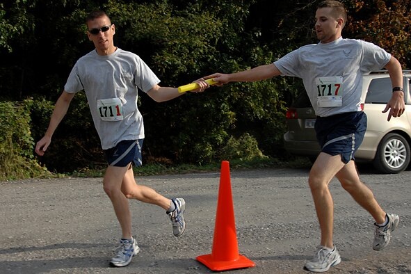 Air Force Reserve intelligence analyst Staff Sgt. Shawn Bell, from the 610th intelligence flight, passes the baton to Tech. Sgt. Eric Miller, another 610th intelligence flight analyst. They were part of a seven man team in the Market to Market Relay Race on Saturday Oct. 11, which started in Omaha's Old Market and finished in Lincoln's Hay Market. The race was the first of its kind consisting of 150 teams of six to eight people and covered 86 miles. (U.S. Air Force Photo Courtesy of 55th Wing Public Affairs)