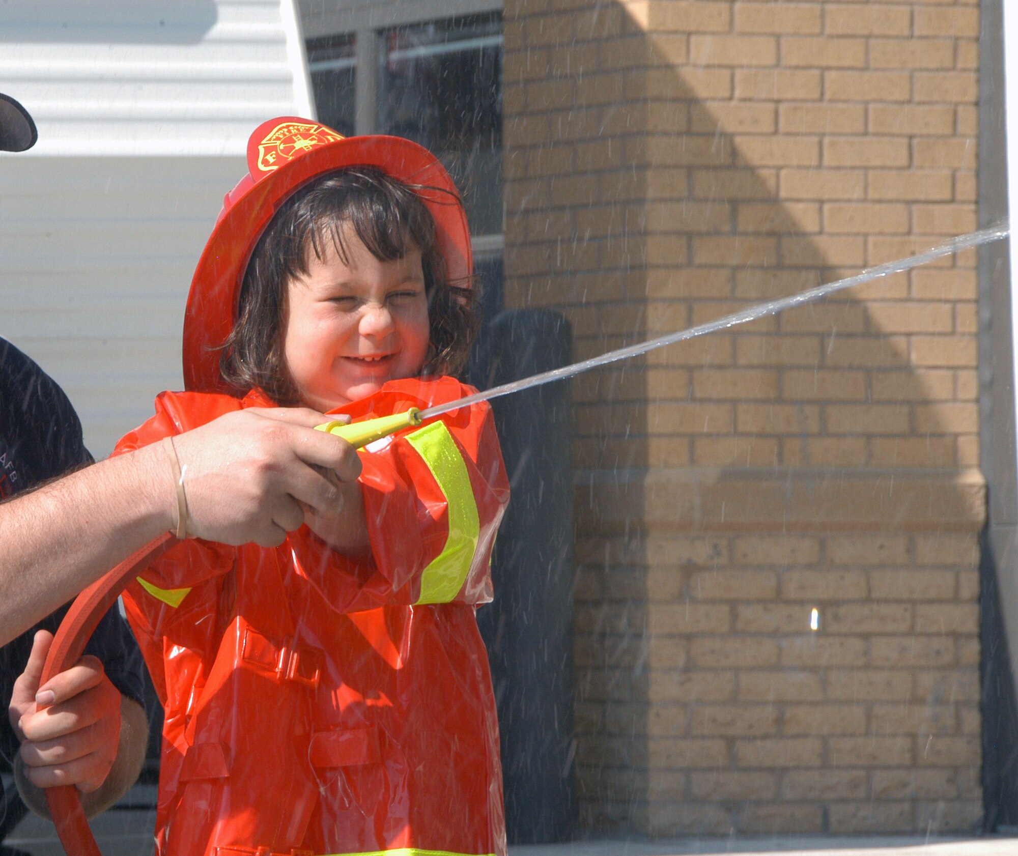 OFFUTT AIR FORCE BASE, Neb. -- Joseaphine Thomas, the three year old daughter of Staff Sgt. Heather Thomas, radiology technician, gets a little wet putting out a simulated fire at a children’s firehouse on display to help understand the feeling of firefighter’s duties. There were various exercises offered to encourage children to respect and understand fire and smoke including a smokehouse that simulated a fire in a child’s home during the 2008 Offutt Firestation Open House Oct. 11. (U.S. Air Force Photo By Jeff Gates)                                                                                                                                                                                                                                                                      