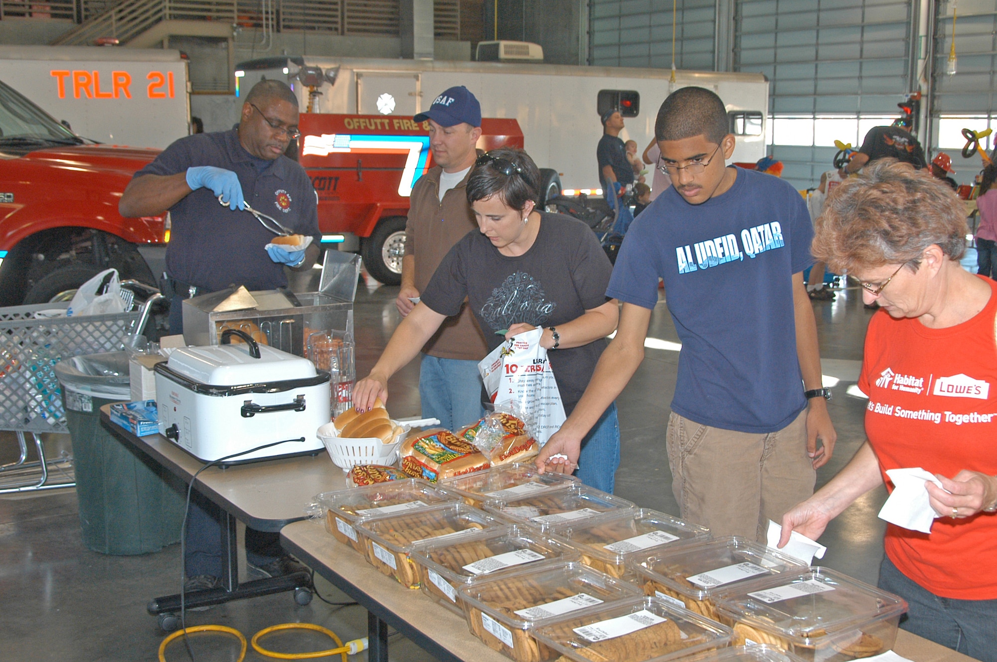 OFFUTT AIR FORCE BASE, Neb. -- Fred Montgomery, firefighter at the Offutt AFB fire station, serves hot dogs to attendees. Complimentary gifts and training aids were also given out for children to teach them fire safety. Various exercises were offered by firefighters for children to understand how to react to a fire in their own home. Many local families attended the 2008 Offutt Firestation Open House held on Oct. 11. (U.S. Air Force Photo By Jeff Gates)                                                                                                                                                                                     