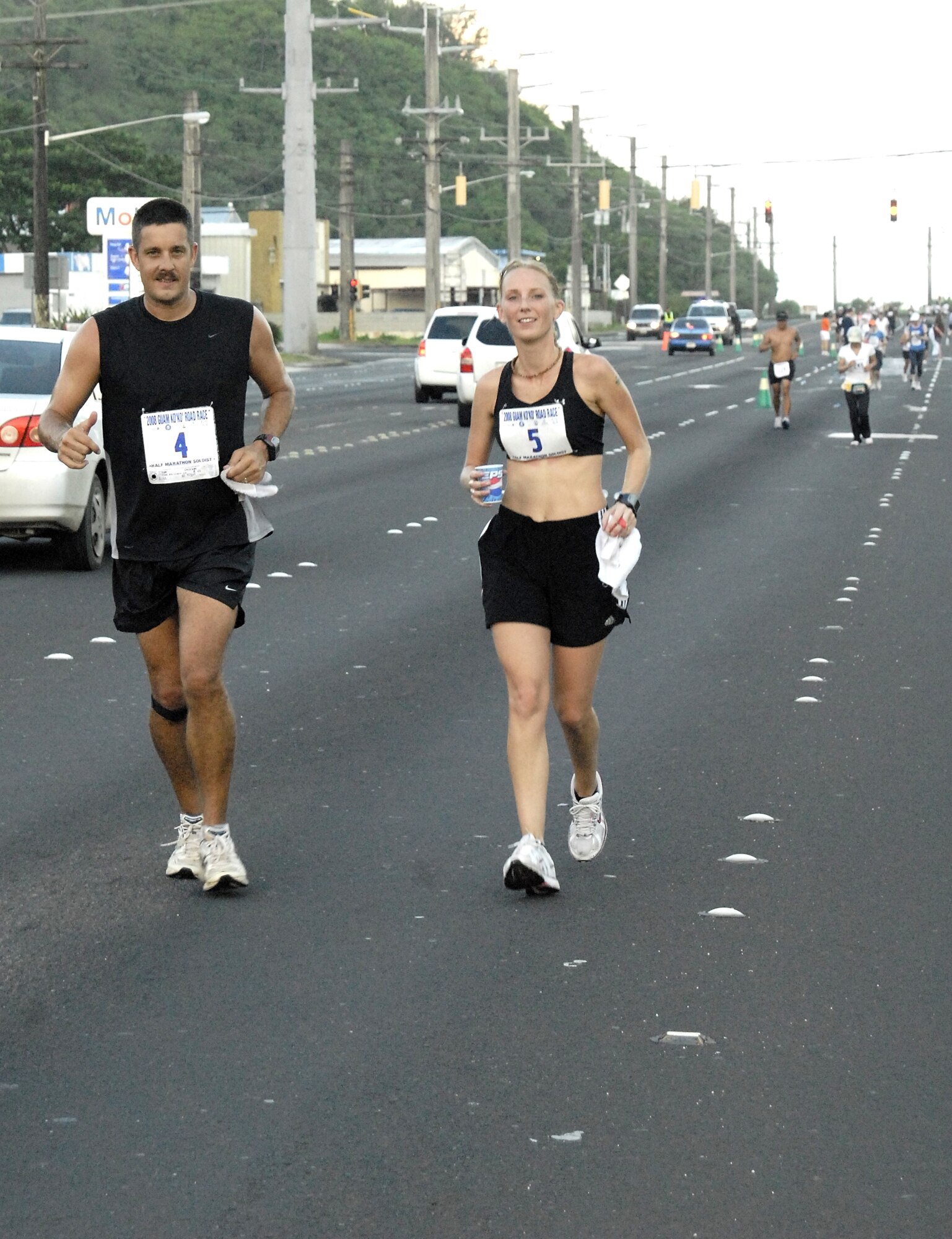 ANDERSEN AIR FORCE BASE, Guam-- Senior Master Sgt. Gregory Stone of the 36th Mobility Response Squadron and his wife Lori make it a family affair during the half-marathon portion of the Guam Ko'ko' Road Race Oct. 19. The Stones spearheaded training runs to prepare Team Andersen personnel participating in this running event. (U.S. Air Force photo by Master Sgt. Lisa M. Zunzanyika)