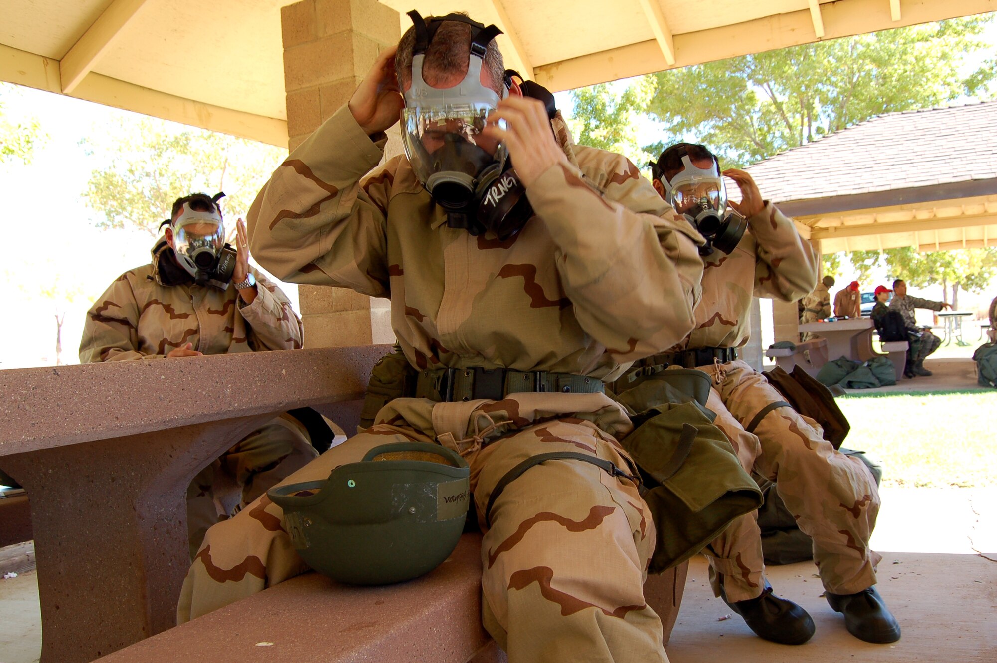 Edwards Airmen don their gas masks during a Phase II exercise at Arnold Park Oct. 20 in preparation for a Unit Compliance Inspection in January. The Airmen also received training on weapons familiarization, self aid buddy care and explosive ordnance identification. (Air Force photo by Senior Airman Julius Delos Reyes)