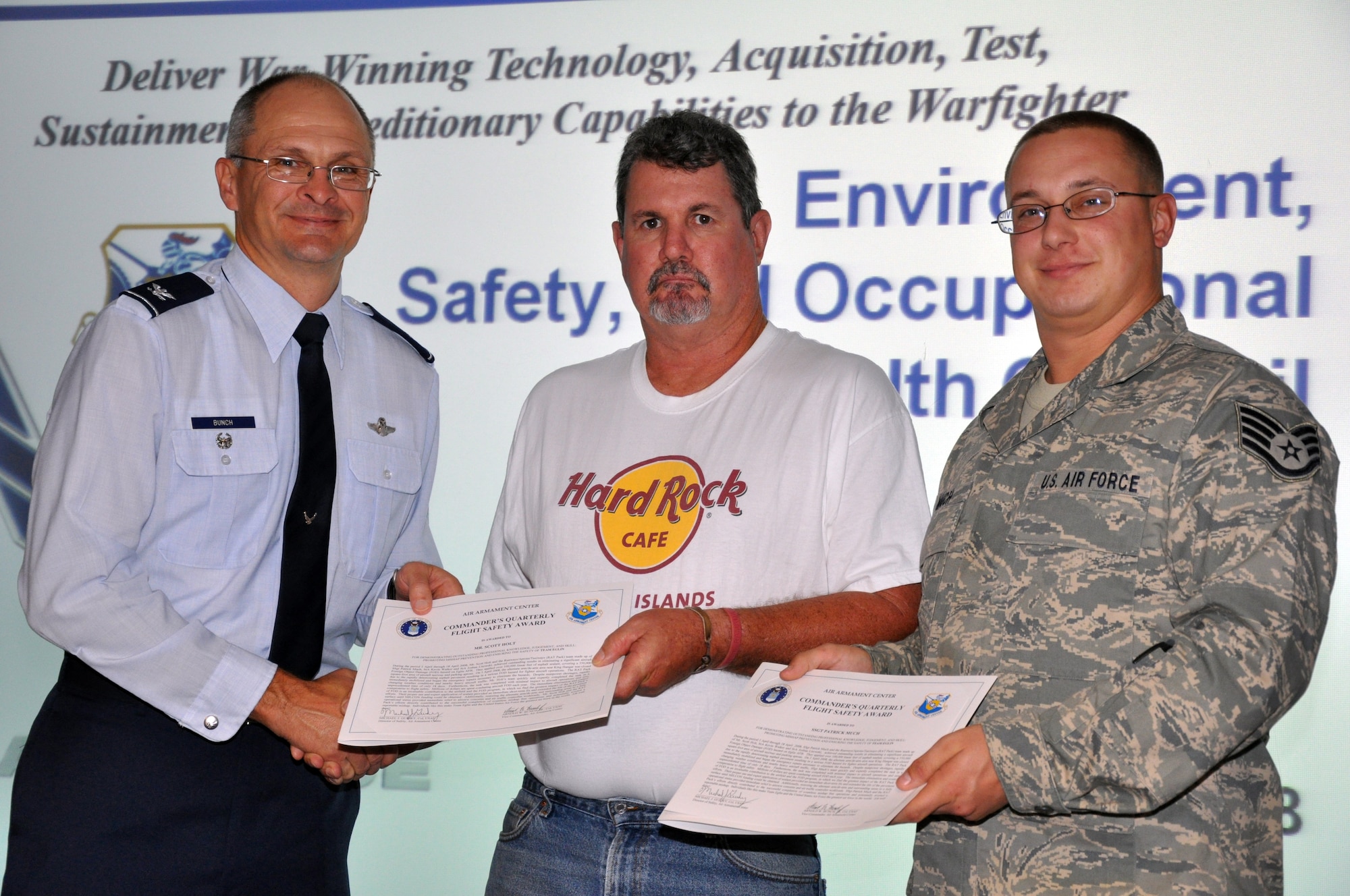 EGLIN AIR FORCE BASE, Fla. -- Col. Arnold Bunch, Air Armament Center vice commander, presents Staff Sgt. Patrick Much and Mr. Scott Holt, 796 Civil Engineer Squadron, with the Commanders Quarterly Flight Safety Award for their outstanding professional knowledge, judgement and skill promoting mishap prevention and ensuring the safety of Team Eglin. (US Air Force photo/ Airman 1st Class Anthony Jennings)