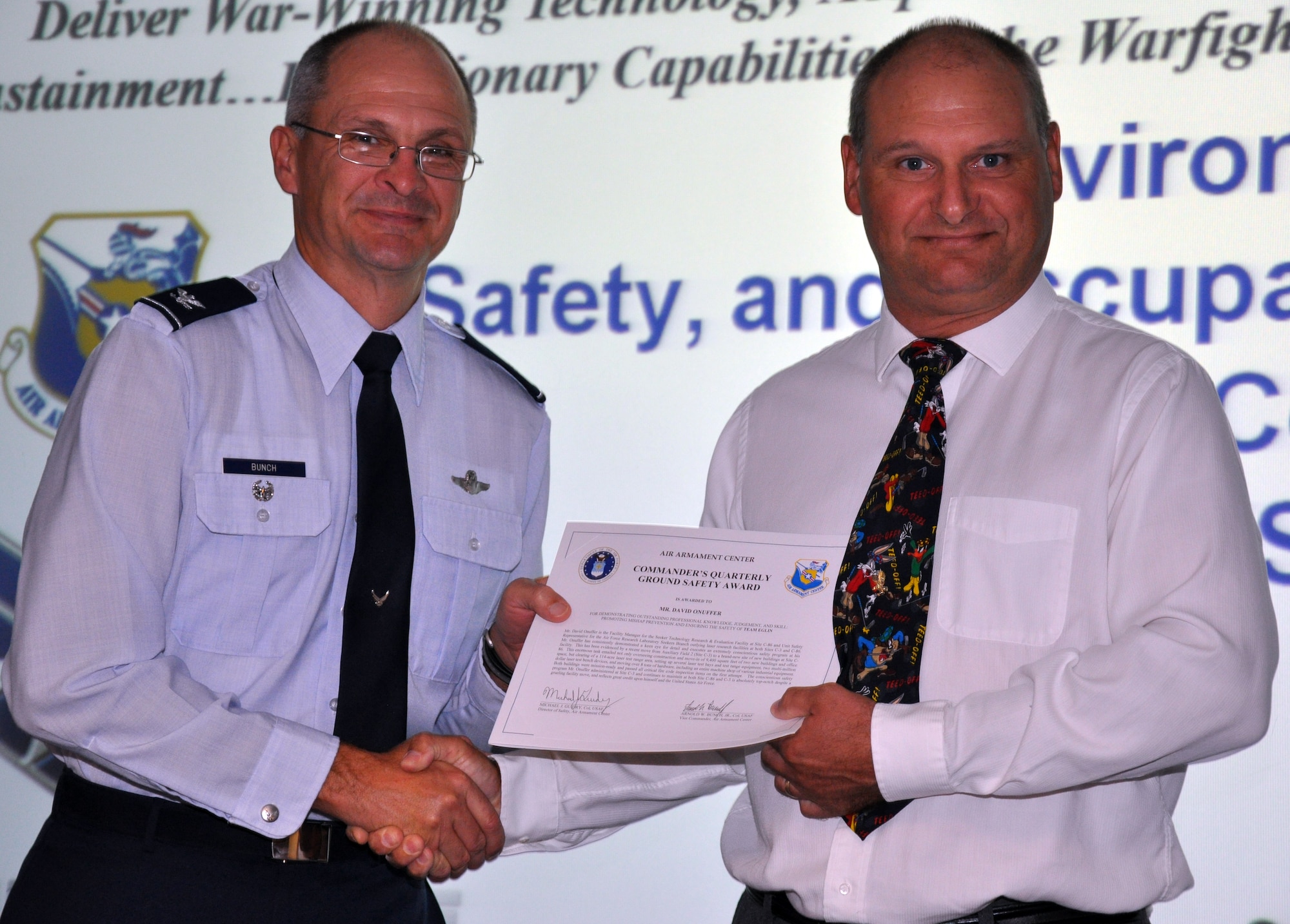 EGLIN AIR FORCE BASE, Fla. -- Col. Arnold Bunch, Air Armament Center vice commander, presents Mr. David Onuffer, Air Force Research Laboratory, with the Commander's Quarterly Flight Safety Award for his outstanding professional knowledge, judgement and skill promoting mishap prevention and ensuring the safety of Team Eglin. (US Air Force photo/ Airman 1st Class Anthony Jennings)