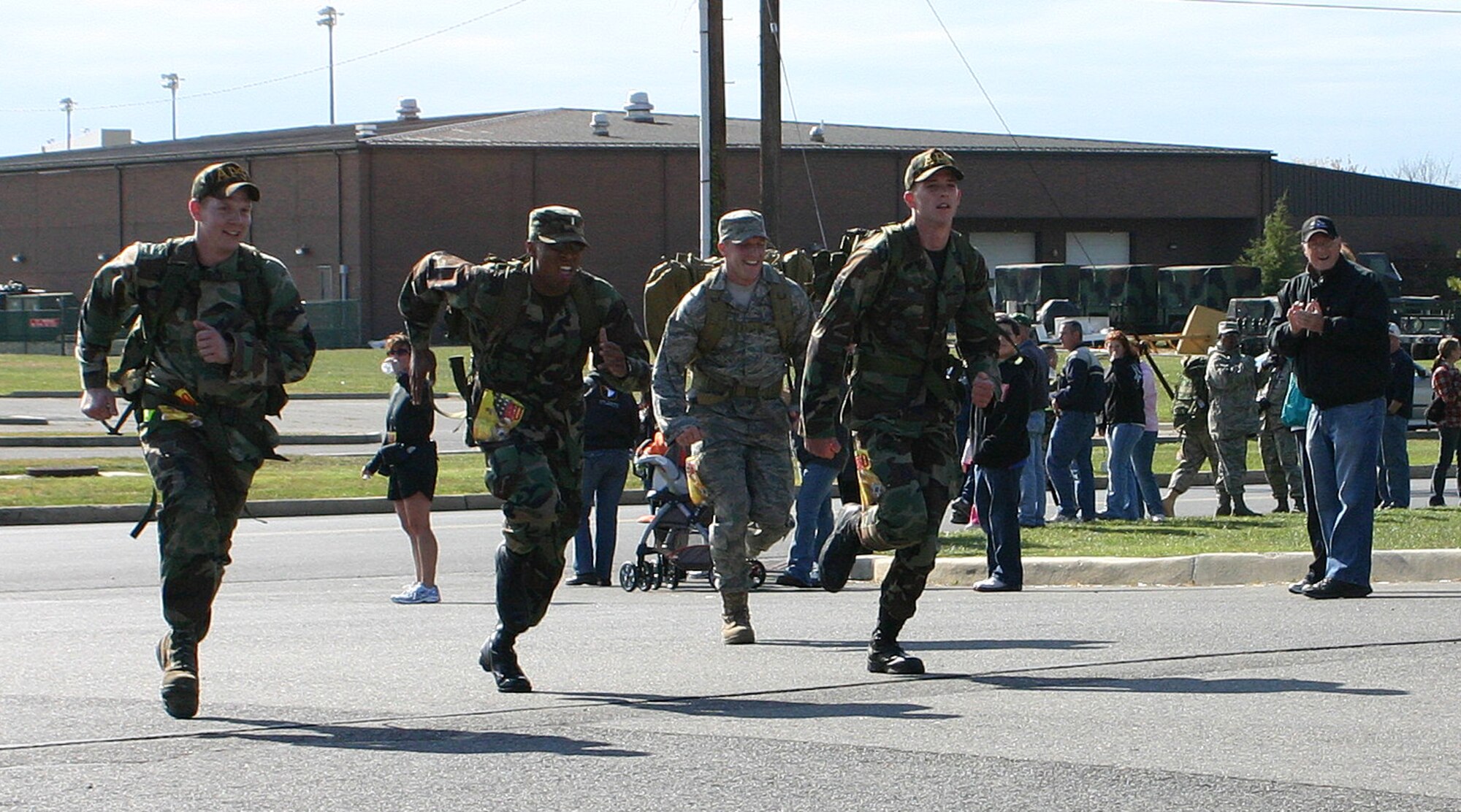 A team competing in the military heavy category races toward the finish line of the Gold Star Mom Ruck March. About 19 members of the Gold Star Moms, an organization of parents who have lost a son or daughter in combat, attended the event held in honor of their sons and daughters. Each member competing in the military heavy category carried a 30-pound pack for the duration of the 10K course; all teams carried a photo or memento provided by a Gold Star Mom honoring her son or daughter who died in combat. (U.S. Air Force photo/Senior Airman Danielle Johnson)