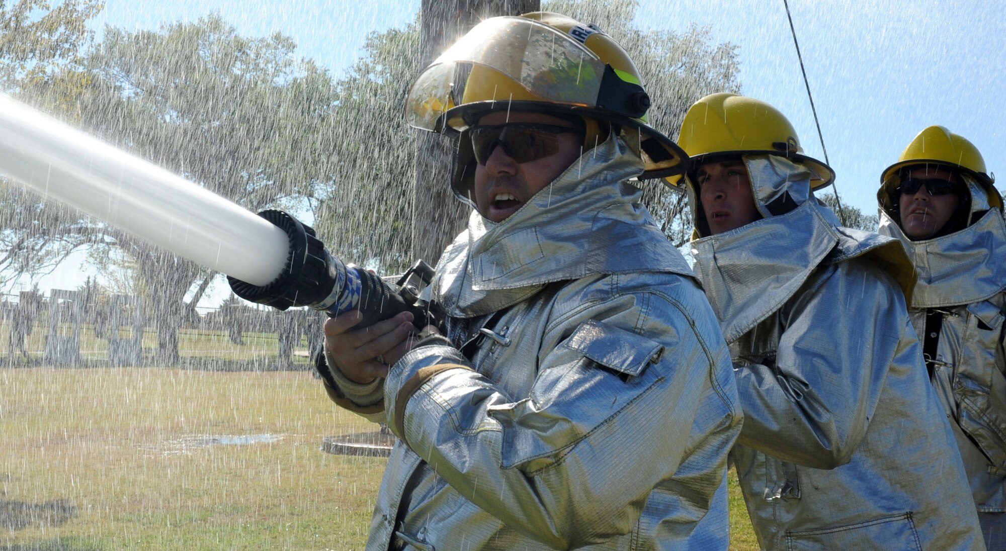 CANNON AIR FORCE BASE, N.M. -- Tech. Sgt. Richard Glockner, Senior Airman Marshall Vines, and Staff Sgt. Eric Bradley, 27th Special Operations Logistics Readiness Squadron, hold a fire hose during a keg challenge at the Fire Prevention Week Muster. The muster concluded fire prevention week, which focused on fire prevention measures that should be taken throughout the year. (U.S. Air Force photo by Airman 1st Class Evelyn Chavez)