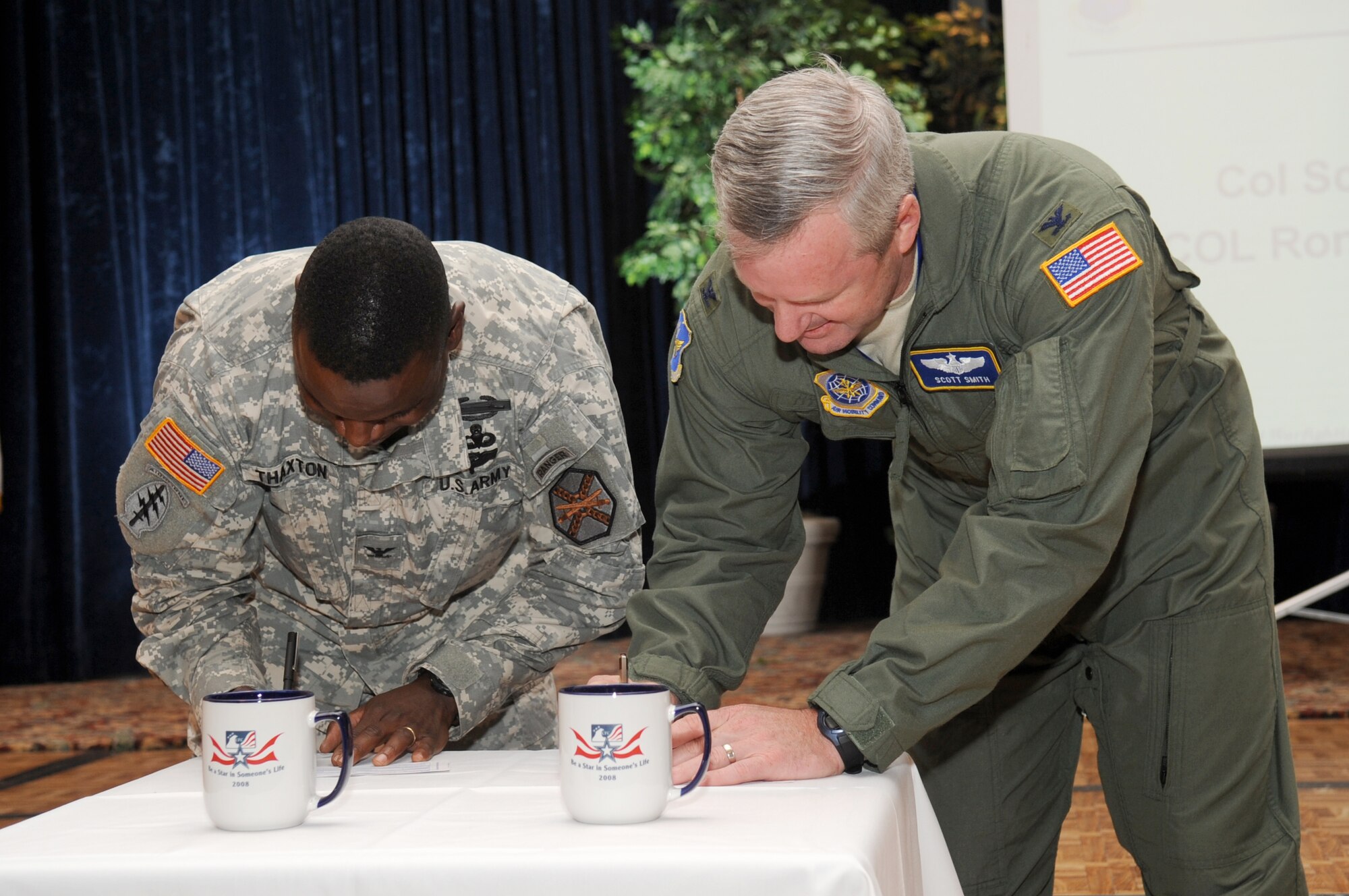 Col. Ronald Thaxton, Fort Dix installation commander, and Col. Scott Smith, 305th Air Mobility Wing vice commander, sign pledge cards at the Combined Federal Campaign kickoff ceremony Oct. 10 at the McGuire Club. The CFC, which continues through Nov. 21, provides federal employees an opportunity to make contributions to charities of their choice, or to no one organization in particular. (U.S. Air Force Photo/Carlos Cintron)
