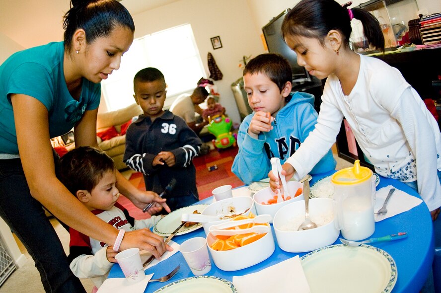 Chase Brooks, age 2, waits patiently while Mrs. Noguez prepares his lunch plate. Following strict FCC program guidelines, Mrs. Noguez provides a well-balanced, homemade meal of teriyaki chicken, rice, fruit and milk for lunch. (U.S. Air Force photo/Abner Guzman)