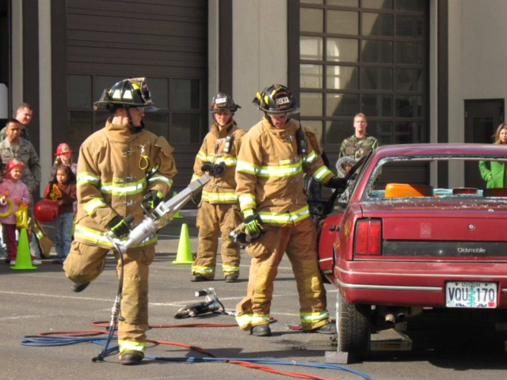 Senior Airman Steve Martinez, 446th Civil Engineer Squadron, left, Fire Captain Sean Harding, center, and Staff Sgt. Tyler Mart, both 62nd CES, perform an auto extrication demonstration during the McChord Fire Department open house Oct. 10 as part of Fire Prevention Week Activities. This year’s theme, Prevent Home Fires, focused on decreasing unattended cooking fires. During the week, the fire department demonstrated response capability and awareness of seatbelt safety. Games and activities for children were also a part of the week’s activities. (U.S. Air Force photo/Sandra Cooper) 