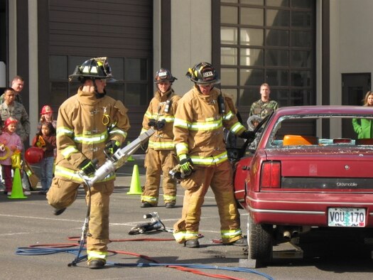 Senior Airman Steve Martinez, 446th Civil Engineer Squadron, left, Fire Captain Sean Harding, center, and Staff Sgt. Tyler Mart, both 62nd CES, perform an auto extrication demonstration during the McChord Fire Department open house Oct. 10 as part of Fire Prevention Week Activities. This year’s theme, Prevent Home Fires, focused on decreasing unattended cooking fires. During the week, the fire department demonstrated response capability and awareness of seatbelt safety. Games and activities for children were also a part of the week’s activities. (U.S. Air Force photo/Sandra Cooper) 