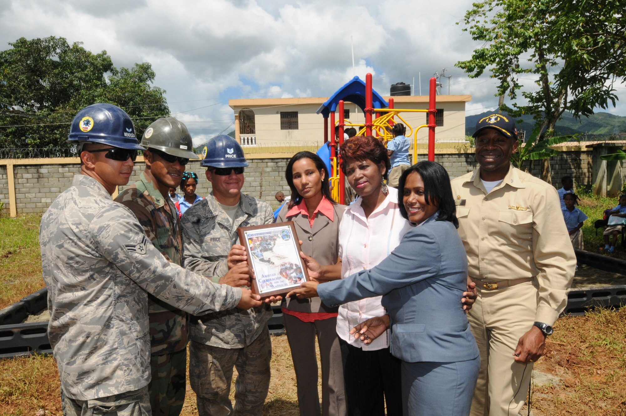 ALTAGRACIA, Dominican Republic -- Navy Capt. Fernandez "Frank" Ponds (far right), Continuing Promise (CP) 2008 mission commander, presents a plaque commemorating the opening of a playground for a local elementary school constructed by Airmen from the 5th Civil Engineer Squadron Prime Base Engineer Emergency Force and Navy Seabees, currently embarked aboard USS Kearsarge (LHD 3). CP 2008 is a collaborative effort between the United States and partner militaries, non-governmental organizations, and partner-nation support organizations to build strong partnerships that can be called upon in the event of a regional situation requiring cooperative solutions. (U.S. Navy Photo by Mass Communication Specialist 1st Class Emmitt J. Hawks)