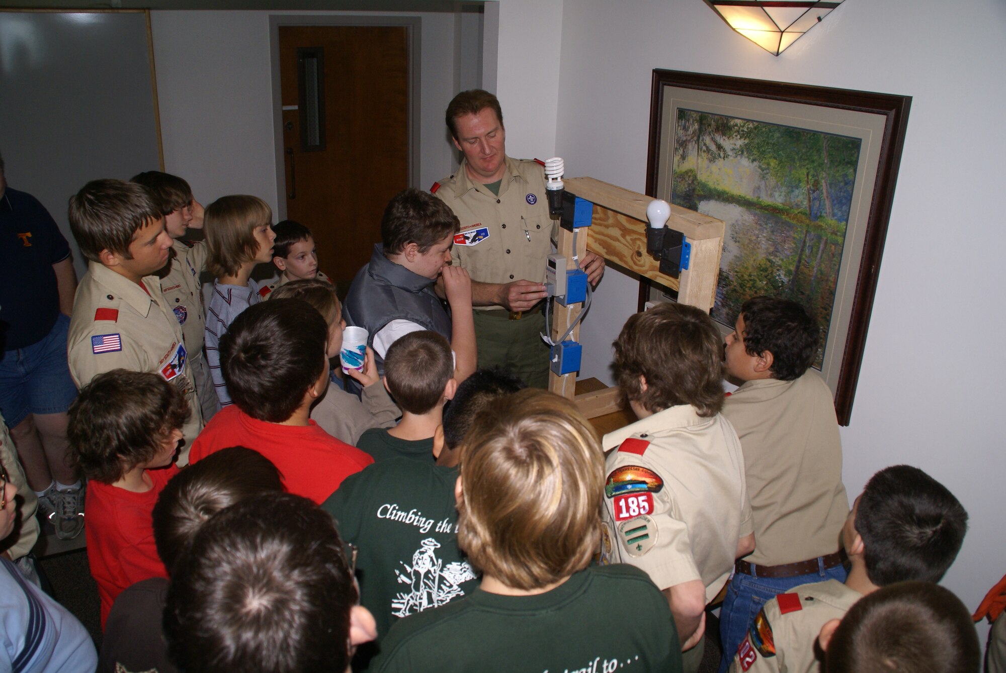Rick McCoy, an Aerospace Testing Alliance energy program manager and an assistant troop leader for Boy Scout Troop 135 in Franklin, Tenn., shows area Boy Scouts how to read the meters on a light board, which compares energy use from an incandescent bulb and a compact florescent lamp. The scouts were participating in a day-long energy awareness merit badge class at the Gossick Leadership Center Oct. 11. (Photo by Philip Lorenz III)
