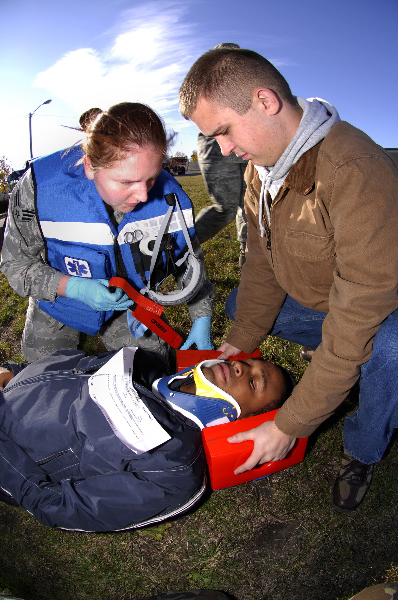 MINOT AIR FORCE BASE, N.D. -- Senior Airman Ashley Swink, 5th Medical Group, and Senior Airman Andre James, 5th Maintenance Squadron, put a neck brace on Airman 1st Class Ashton Simpson, 5th Civil Engineer Squadron, during a simulated chemical attack on the gym during an All Hazards Response Training exercise here Oct. 15. The exercise was designed to test responding agencies’ capabilities during a crisis scenario. (U.S. Air Force photo by Airman 1st Class Jesse Lopez)