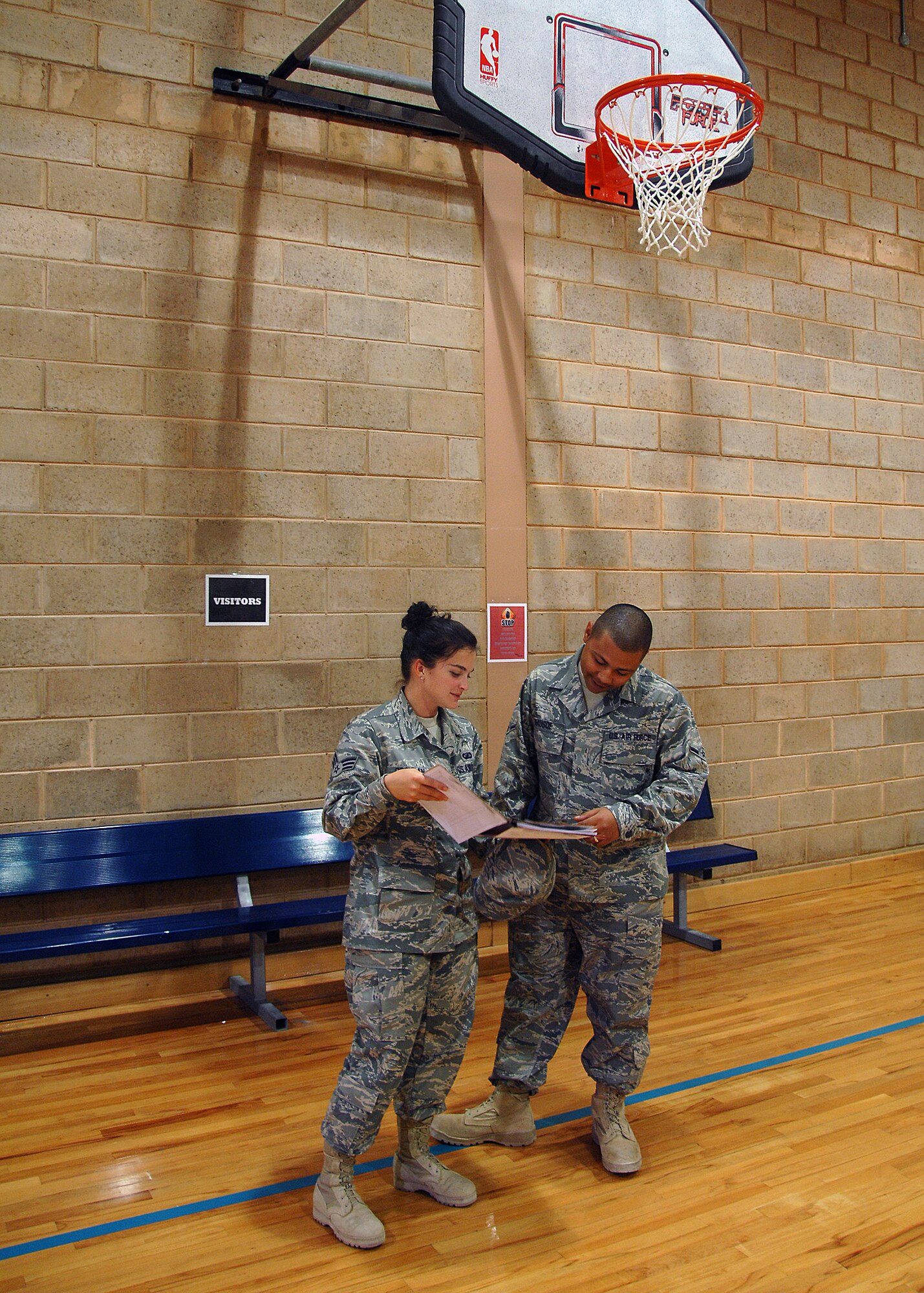 SOUTHWEST ASIA -- Senior Airman Abbigayle Cochran, a contracting specialist with the 386th Expeditionary Contracting Squadron, talks with Airman Cambrian Hausoe, fitness center representative about how the condition of the basketball court refinishing is holding up on Oct. 15 at a base in Southwest Asia. The 386th ECONS acquired a contract with a local vendor to refinish the basketball court once a year. The mission of the 386th ECONS is to provide superior acquisition support to the 386th Air Expeditionary Wing and associated units quickly, legally, and effectively. Airman Cochran is deployed from Patrick Air Force Base, Fla. Airman Hausoe is deployed from Malmstrom Air Force Base, Mont. (U.S. Air Force photo/Tech. Sgt. Raheem Moore)