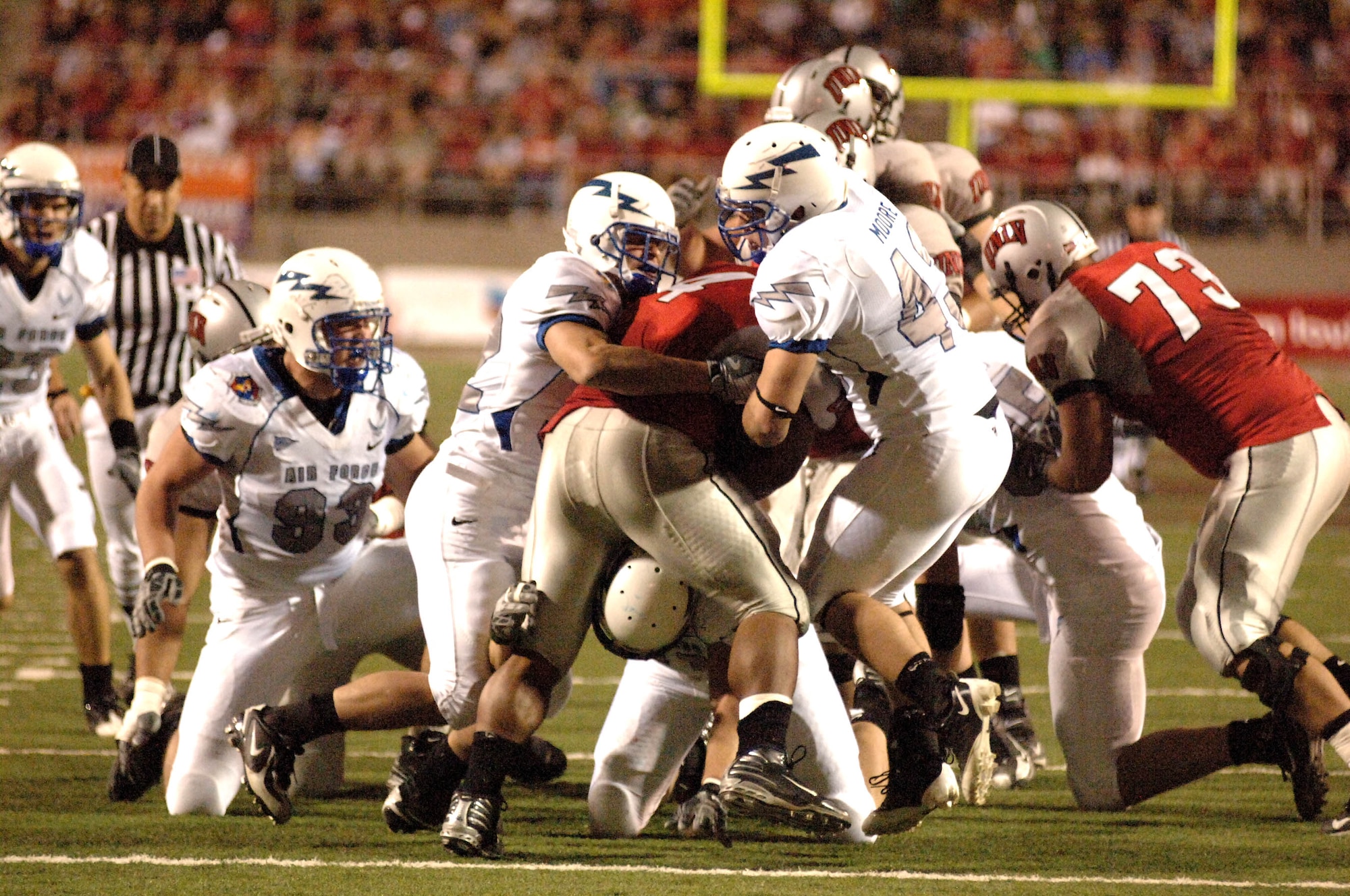 U.S. Air Force Academy defenders Hunter Altman (left), Ryan Kemp (bottom) and Justin Moore (right), combine to stuff the hole with University of Nevada, Las Vegas tailback Frank Summers Oct. 18 in Las Vegas. The Falcons won 29-28 and improved to 5-2 on the season and 3-1 in the Mountain West Conference. (U.S. Air Force photo/John Van Winkle) 
