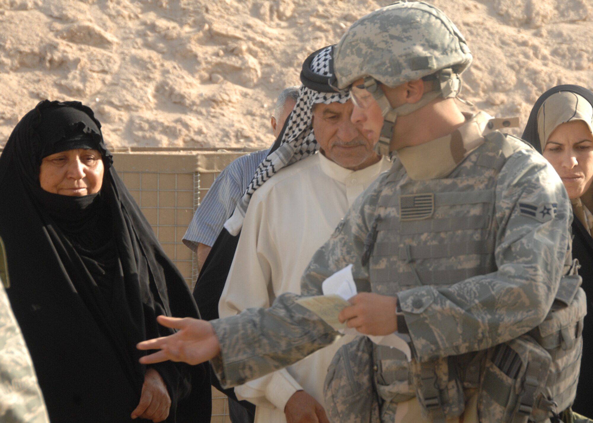 CAMP BUCCA, IRAQ -- A security forces member assigned to the 586th Air Expeditionary Group escorts a group of Iraqi visitors to a security checkpoint on Oct. 4 at Camp Bucca, Iraq. The 586th AEG provides security for the camp’s visitation center, where nearly 400 visitors are allowed to visit daily with detainees being held at the Theater Internment Facility. 