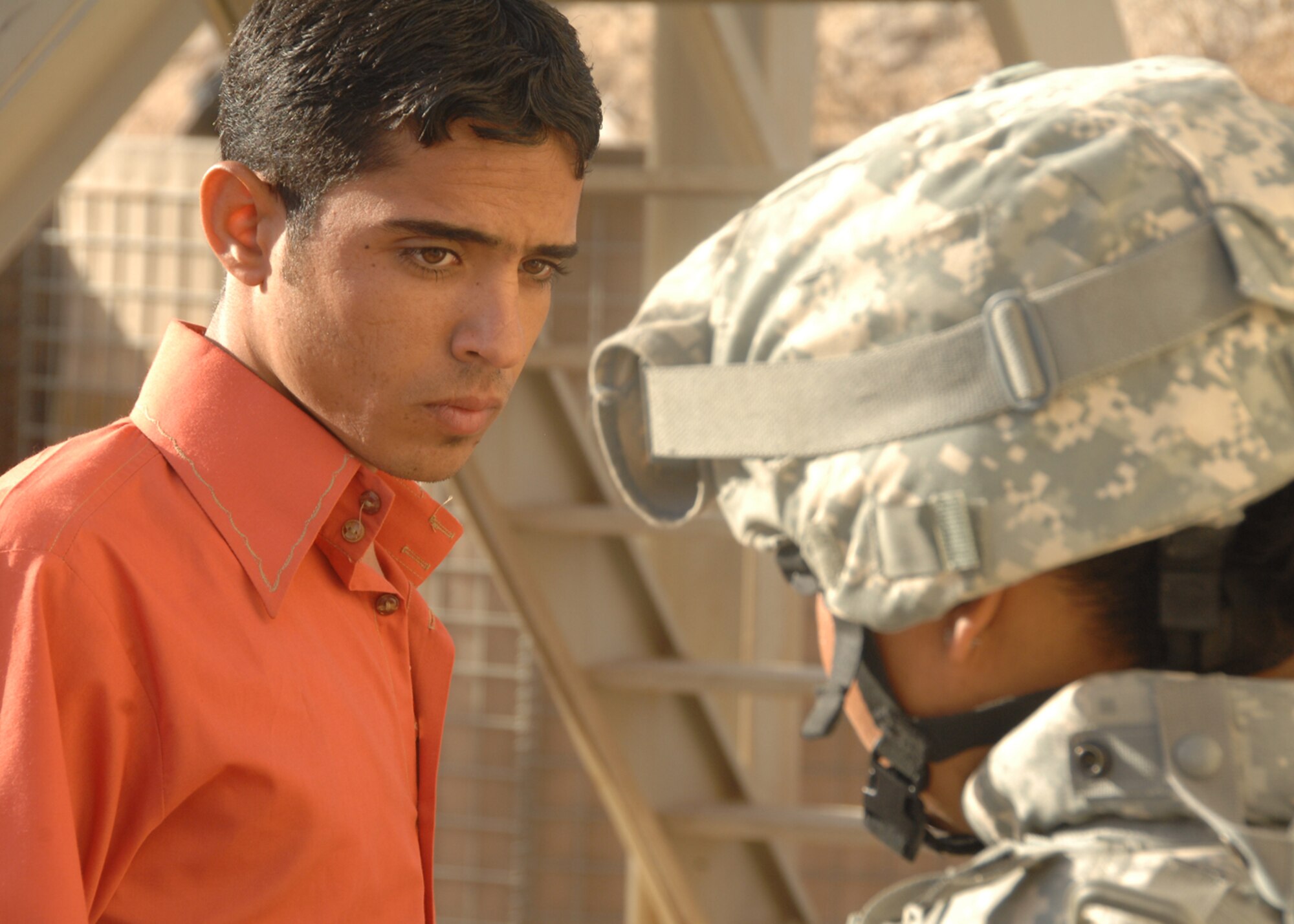 SOUTHWEST ASIA -- An Iraqi man waits for permission to proceed through a security checkpoint manned by Senior Airman Naomi Espinoza, 586th Air Expeditionary Group, on Oct. 4 at Camp Bucca, Iraq. The 586th AEG provides security for the camp’s visitation center, where nearly 400 visitors are allowed to visit daily with detainees being held at the Theater Internment Facility. Airman Espinoza is deployed from Royal Air Force Lakenheath, England.