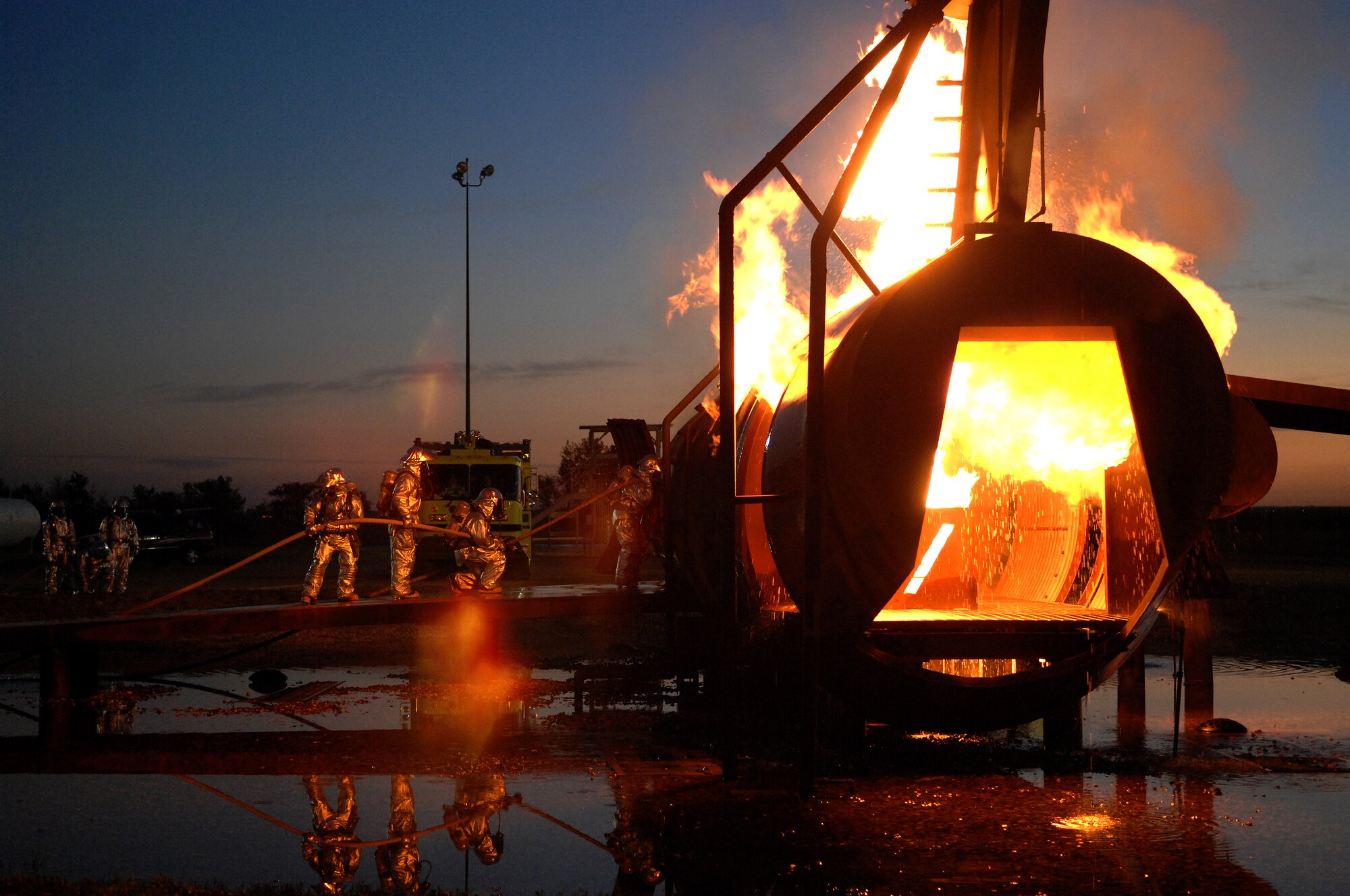 MINOT AIR FORCE BASE, N.D. – Firefighters from the 5th Civil Engineer Squadron practice fighting an aircraft fire during a training session at the base’s live-burn trainer here Oct. 2.  Air Force firefighters are mandated by the Federal Aviation Administration to pass bi-annual recertification training on aircraft fires. (U.S. Air Force photo by Senior Airman Kelly Timney)