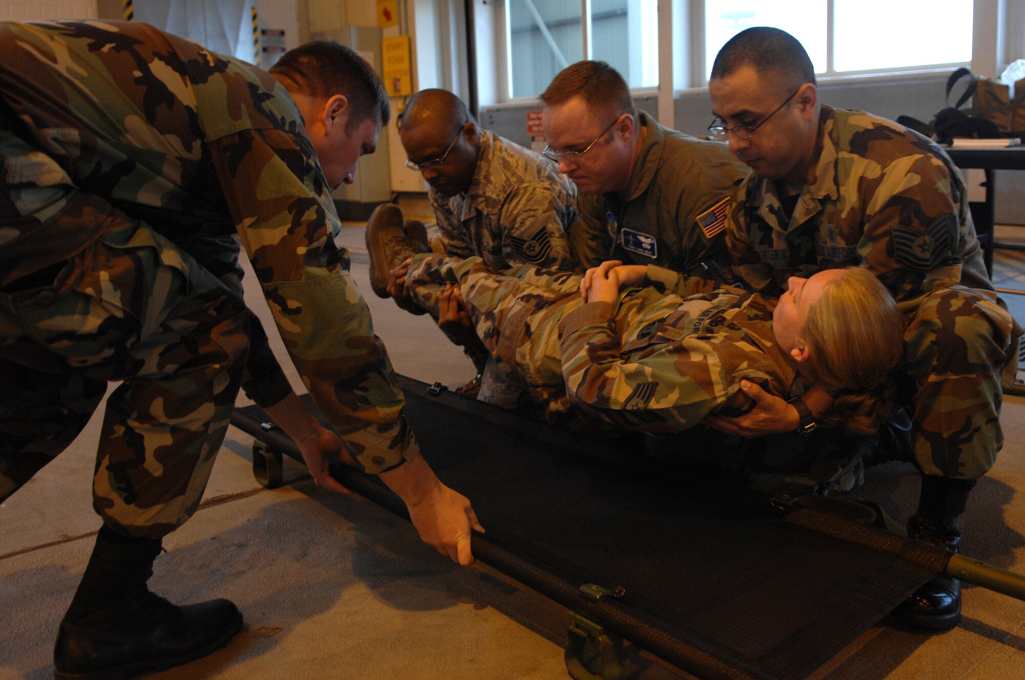 Instructors and participants of Warrior Preparation Day exercise methods of safely loading an injured victim onto a litter, Ramstein Air Base, Germany, Oct. 17, 2008. Warrior Prep Day is a training effort to prepare Airmen of all ranks for upcoming deployments by instructing them on the potential threats and effective emergency response actions in a deployed enviroment. (U.S. Air Force photo by Airman 1st Class Tony R. Ritter)(Released)