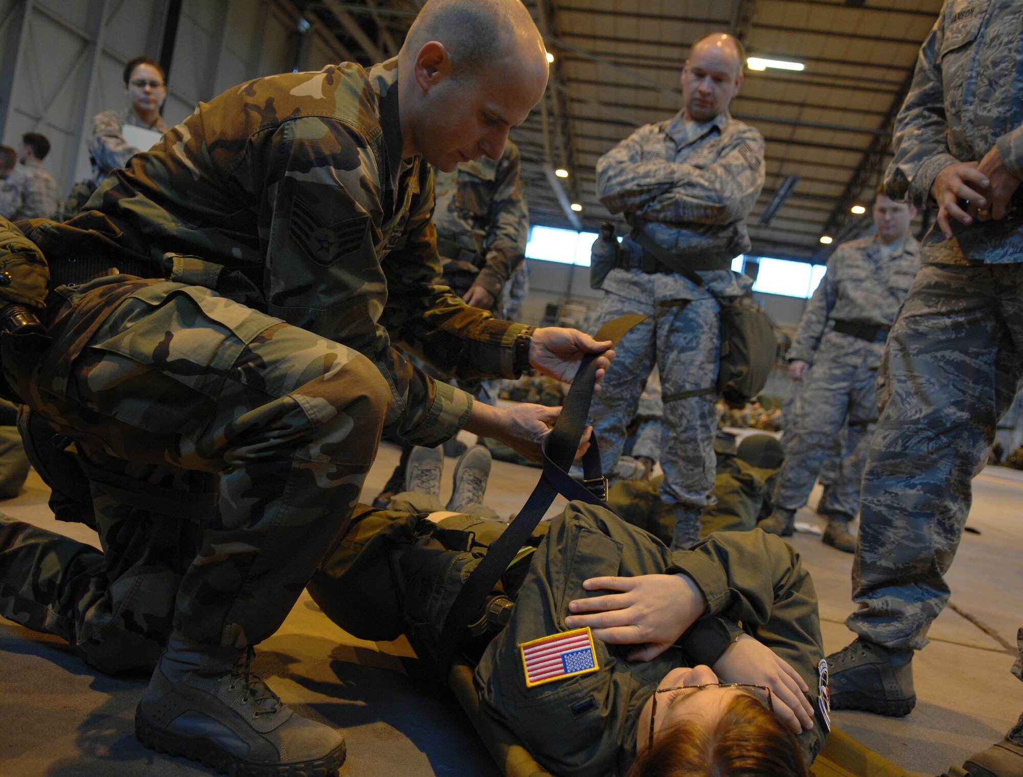 Staff Sgt. Christopher Williams, 86th Operations Support Squadron, uses a BDU belt as an improvision to safely secure an injured victim to a litter, during an exercise at Warrior Preparation Day, Ramstein Air Base, Germany, Oct. 17, 2008. Warrior Prep Day is a training effort to prepare Airmen of all ranks for upcoming deployments by instructing them on the potential threats and effective emergency response actions in a deployed enviroment. (U.S. Air Force photo by Airman 1st Class Tony R. Ritter)(Released)