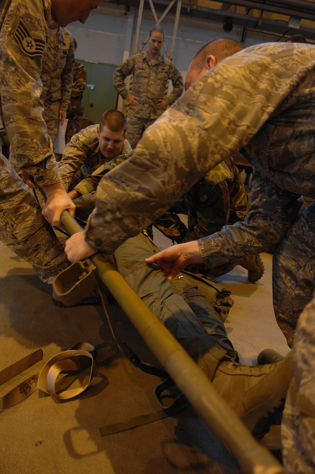 Participants of Warrior Preparation Day exercise methods of safely loading an injured victim onto a litter, Ramstein Air Base, Germany, Oct. 17, 2008. Warrior Prep Day is a training effort to prepare Airmen of all ranks for upcoming deployments by instructing them on the potential threats and effective emergency response actions in a deployed enviroment. (U.S. Air Force photo by Airman 1st Class Tony R. Ritter)(Released)