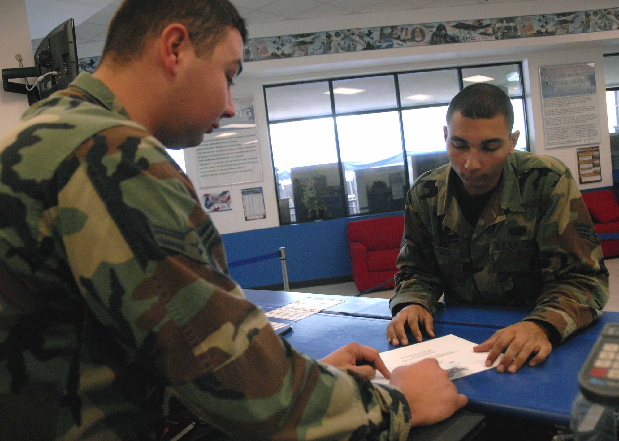 OSAN AIR BASE, Republic of Korea -- Airman 1st Class Justin Mays, (left), postal clerk, explains the “Track Your Vote” Program to Senior Airman Jason Brandon, 51st Communications Squadron. “Track Your Vote” gives Team Osan members the option to track their absentee ballots from Osan to its final destination. (U.S. Air Force photo/Staff Sgt. Candy Knight)