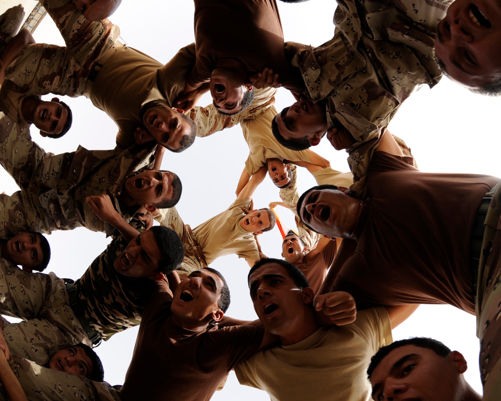 AL TAJI AIR BASE, Iraq -- Iraqi air force warrant officers form a human pyramid for an airman to climb on top and wave the Iraqi flag during a parade practice at Al Taji Air Base, Iraq on Sept. 28. (U.S. Air Force photo/Staff Sgt. Paul Villanueva II)