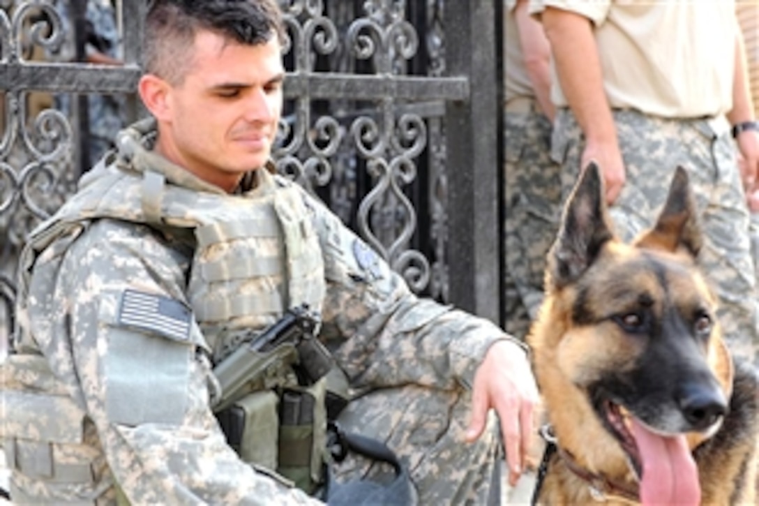 U.S. Air Force Staff Sgt. Michael Marks spends a little time with his Military Working Dog "Dasty" before an outdoor concert in downtown Baquobah, Iraq, Oct. 13, 2008. Marks and Dasty are part of the security team for the 1st Armored Division Band performing the History of American Music for the local Iraqis.    
