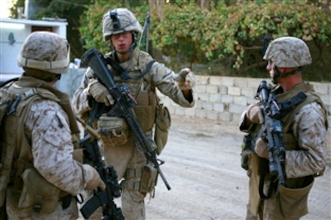 U.S. Marine Corps Cpl. Brian Roarke (center), shows Sgt. Dante Sevieri (right), a squad leader, and Staff Sgt. Jaime Benevides, platoon sergeant, both with Provisional Rifle Platoon 3, Regimental Combat Team 5, where there are people who have supported insurgents in the past, while on a patrol in Rawah, Iraq, Oct. 10, 2008. Marines with Provisional Rifle Platoon 3 assumed control of two traffic control points from 1st Platoon, Fox Company.