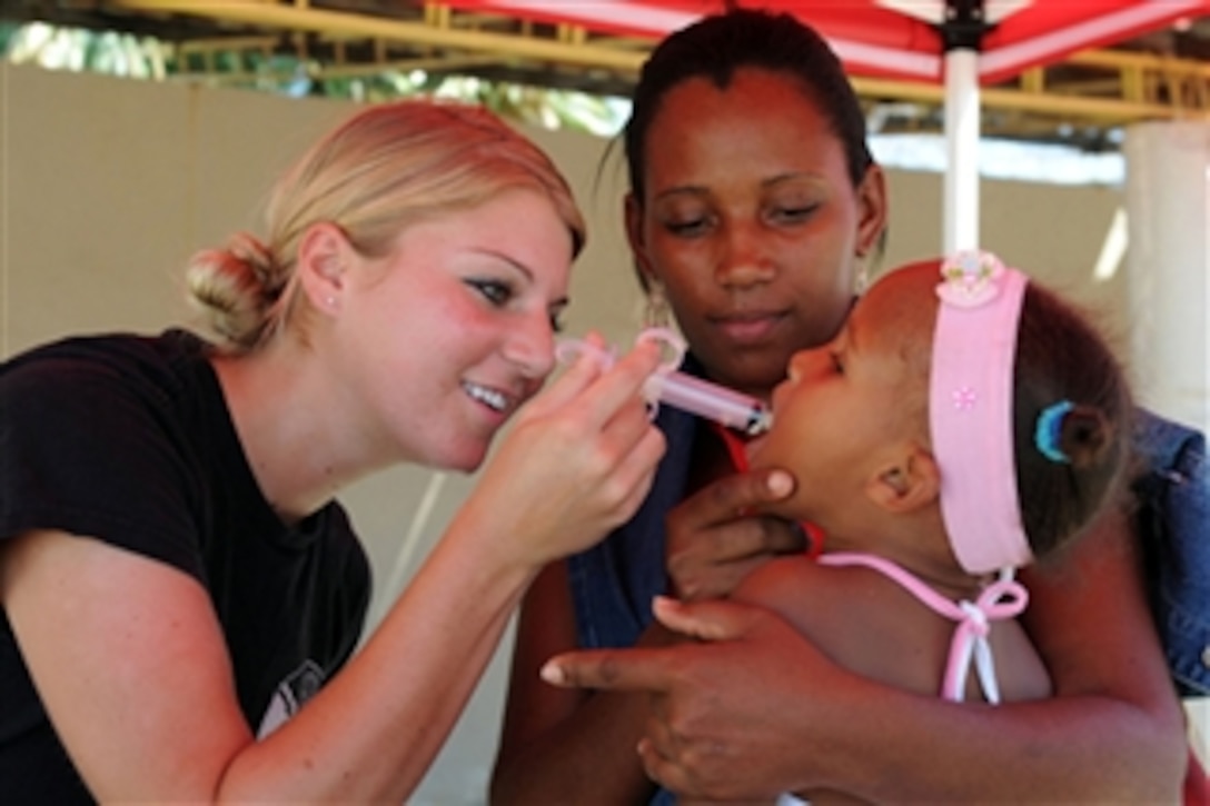 U.S. Air Force Senior Airman Alex Olson, an augmentee embarked aboard the amphibious assault ship USS Kearsarge (LHD 3), administers de-worming medication to a young patient during medical operations at the Las Calderas Naval Base in Dominican Republic on Oct. 10, 2008.  The Kearsarge is supporting the Caribbean phase of Continuing Promise 2008, an equal-partnership mission involving the United States, Canada, the Netherlands, Brazil, France, Nicaragua, Colombia, Dominican Republic, Trinidad and Tobago and Guyana.  