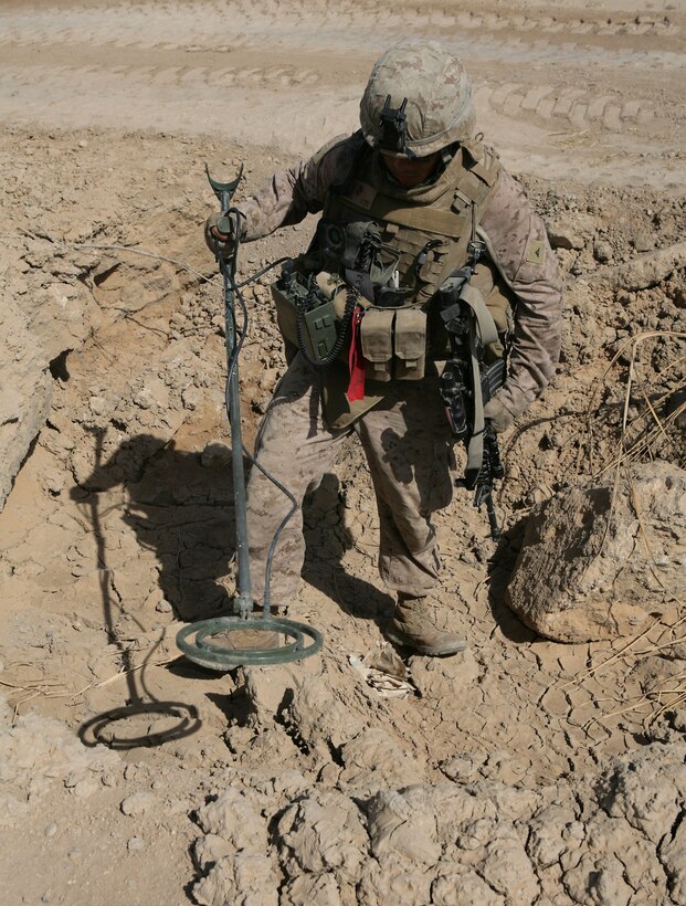 An engineer with Task Force 1st Battalion, 3rd Marine Regiment, Regimental Combat Team 1, scans for weapons caches in northern Karmah near the company’s rural outpost, Oct. 22. Marines there have been finding weapons caches almost daily.