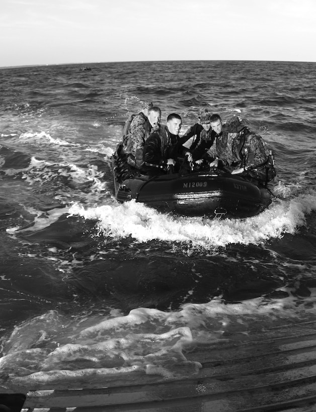 Force Reconnaissance Marines approach a beachhead in a zodiac, a small rubber craft designed to transport up to eight men.