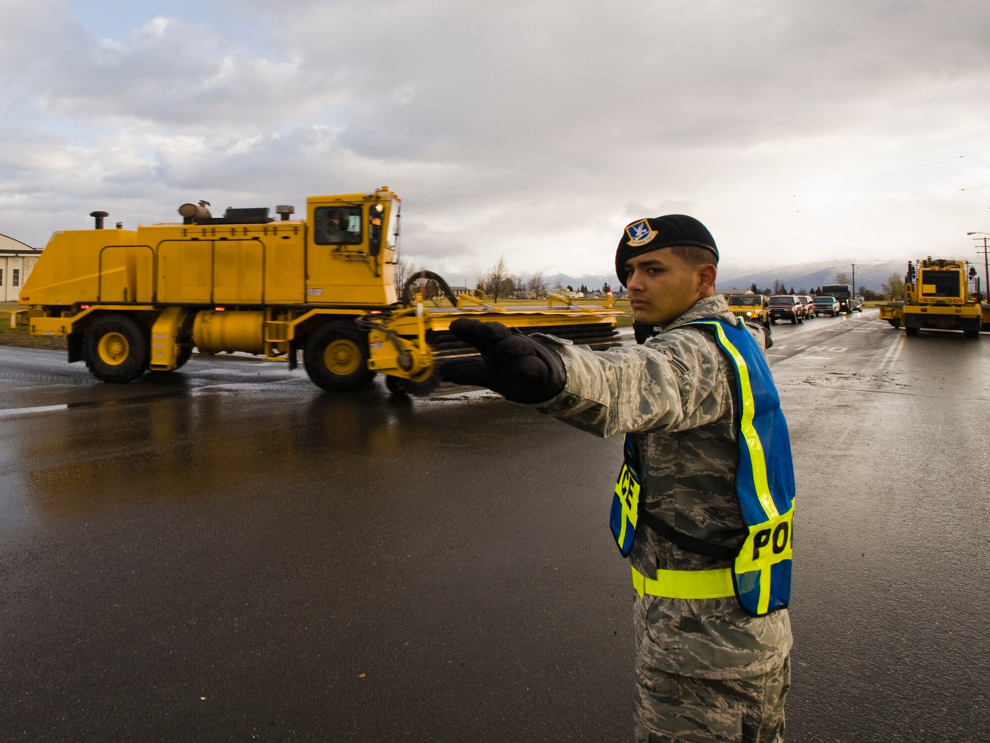 ELMENDORF AIR FORCE BASE Alaska -- Airman 1st Class Efrain Lopez, 3rd Security Forces Squadron, tops traffics as snow removal vehicles pass during the snow parade here Oct. 10. The 3rd Civil Engineer Squadron showcases all their equipment to remove snow for the upcoming winter during the parade. (U.S. Air Force photo/Staff Sgt. Joshua Garcia)