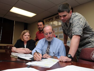 (From right to left) Lt. Col. Chris Crane, 12th Comptroller Squadron commander, Bert Dycus, Financial Management Analysis Flight chief, Cecilio Coronado, lead accountant, and Pam Arserio, lead analyist, review a list of projects that were funded and paid for during Fiscal 2008. (U.S. Air Force photo by Rich McFadden)