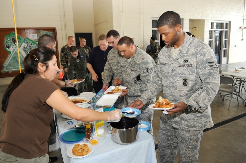 Georgia Dupuis, 305th Security Forces Squadron, serves a traditional Sioux dessert made with blueberries to Staff Sgt. Damien Needom, also with the 305th SFS, at the Native American Heritage Luncheon Oct. 16. The event was part of Native American Heritage Month celebrations, which will continue through the month of November. (U.S. Air Force photo/Carlos Cintron)
