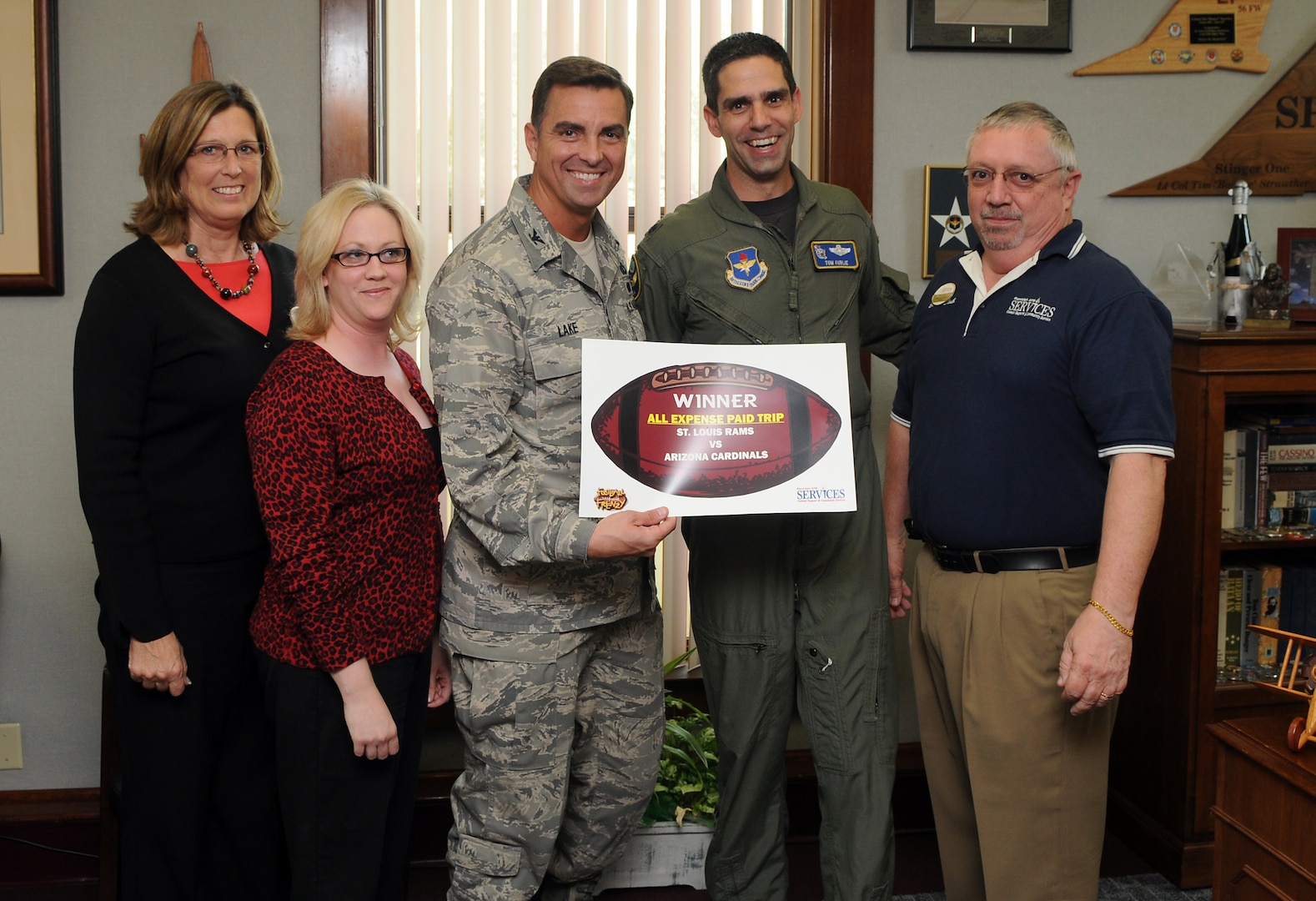 Col. Alan Lake (left), 12th Mission Support Group commander, surprises Lt. Col. Tom Kublie, 19th Air Force Undergraduate Training Branch chief, on Oct. 21 with an all-expense paid trip for two to watch the Arizona Cardinals play the St. Louis Rams on Dec. 7. Colonel Kublie entered the Football Frenzy competition held by the Air Force Services Agency and was selected as the regular season game package winner. The grand prize, which includes an all-expense paid trip for two to Super Bowl XLIII in Tampa Bay, Fla., will be held in early January. Services Club members who attend a Football Frenzy celebration at the enlisted or officers' club can enter by filling out a form, with no purchase neccessary. (U.S. Air Force photo by Rich McFadden)